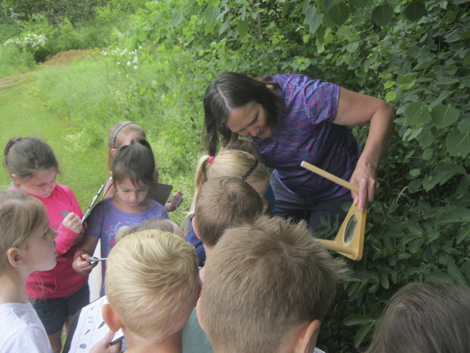 Mrs. Thompson shows students how to look closely at nature with a magnifying glass.