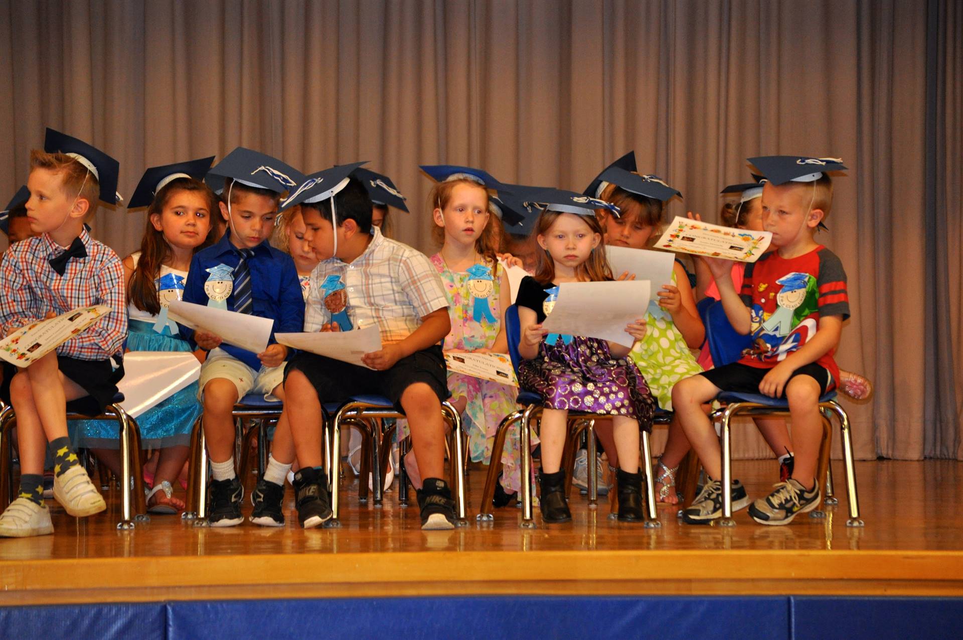 First graders admire their certificates of graduation on stage!