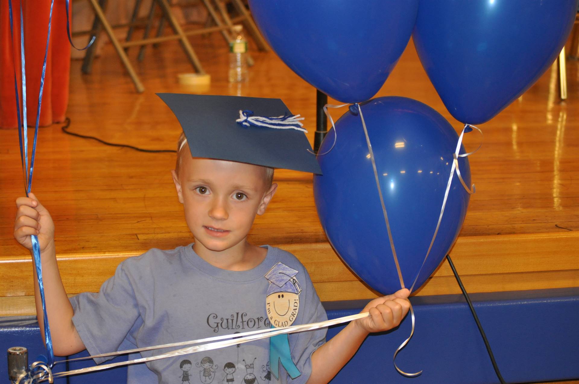 A student holds balloons to celebrate after the graduation ceremony.