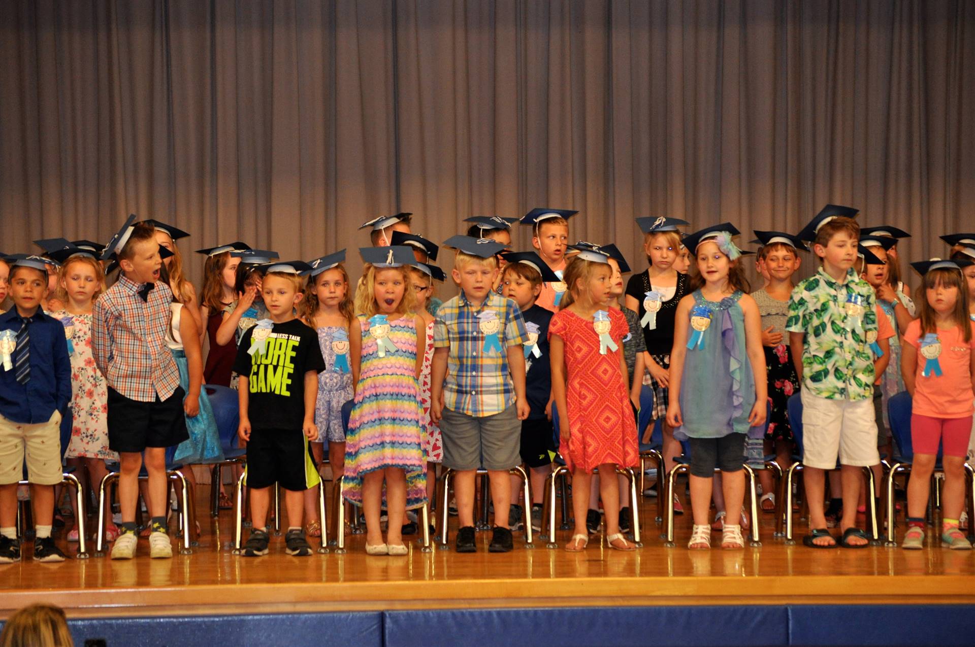 first graders sing a song on stage.