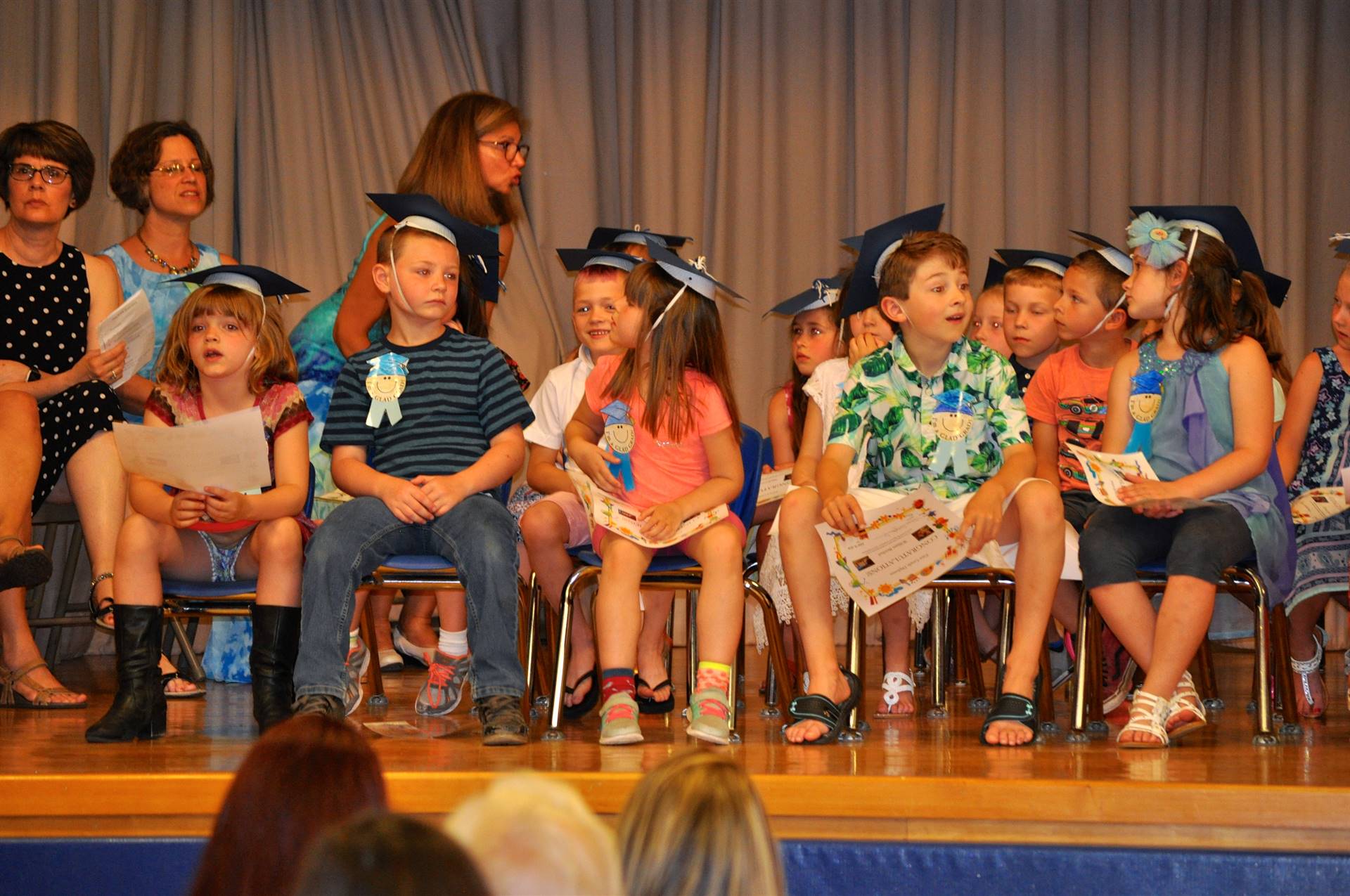 First graders admire their certificates of graduation on stage!