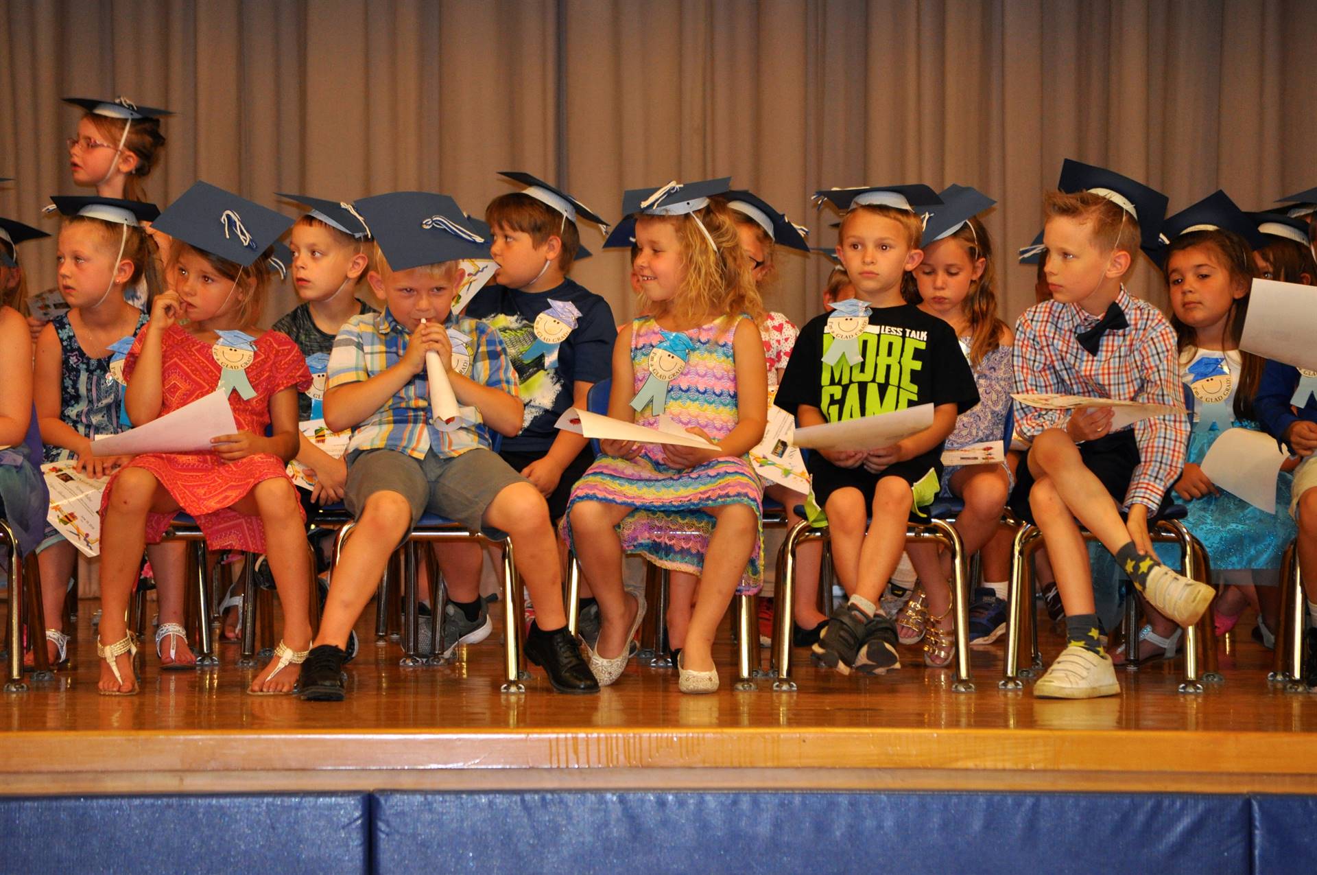  First graders admire their certificates of graduation on stage!