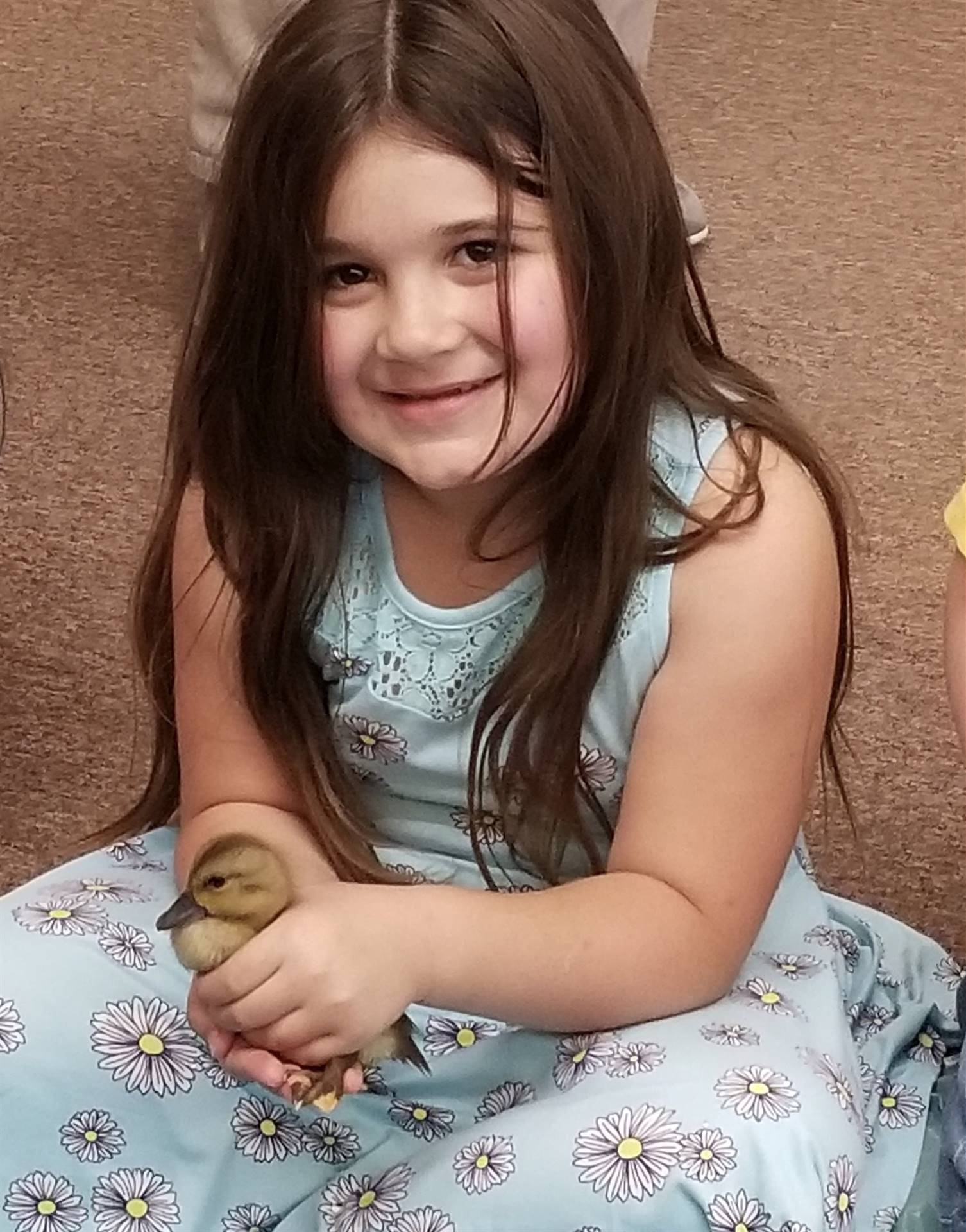 first grader holds a duckling.