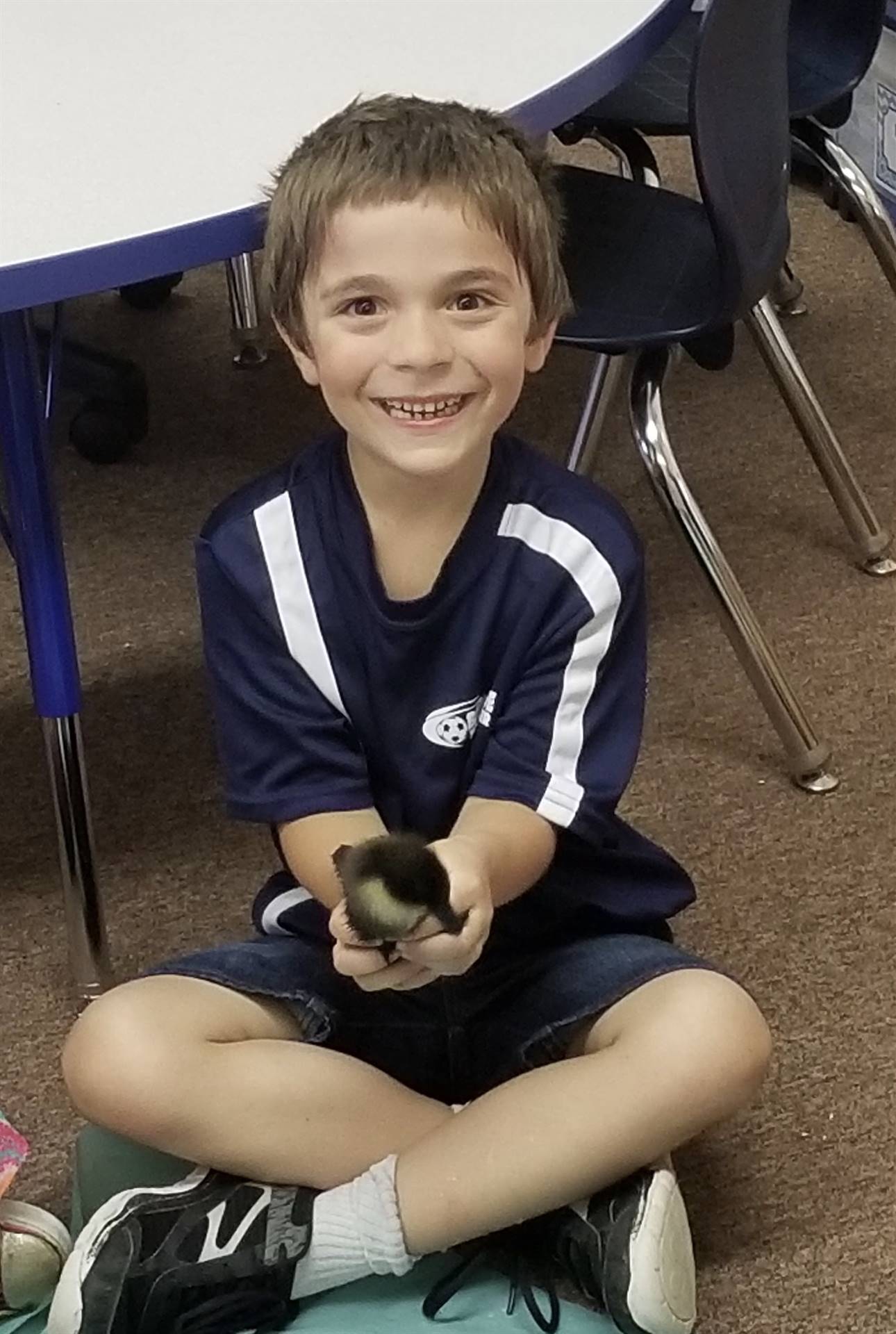 first grader holds a duckling.