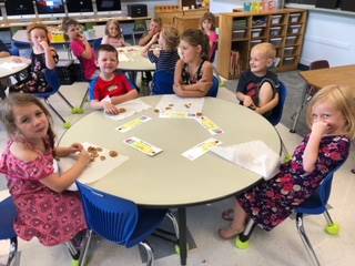 Students color at a table.