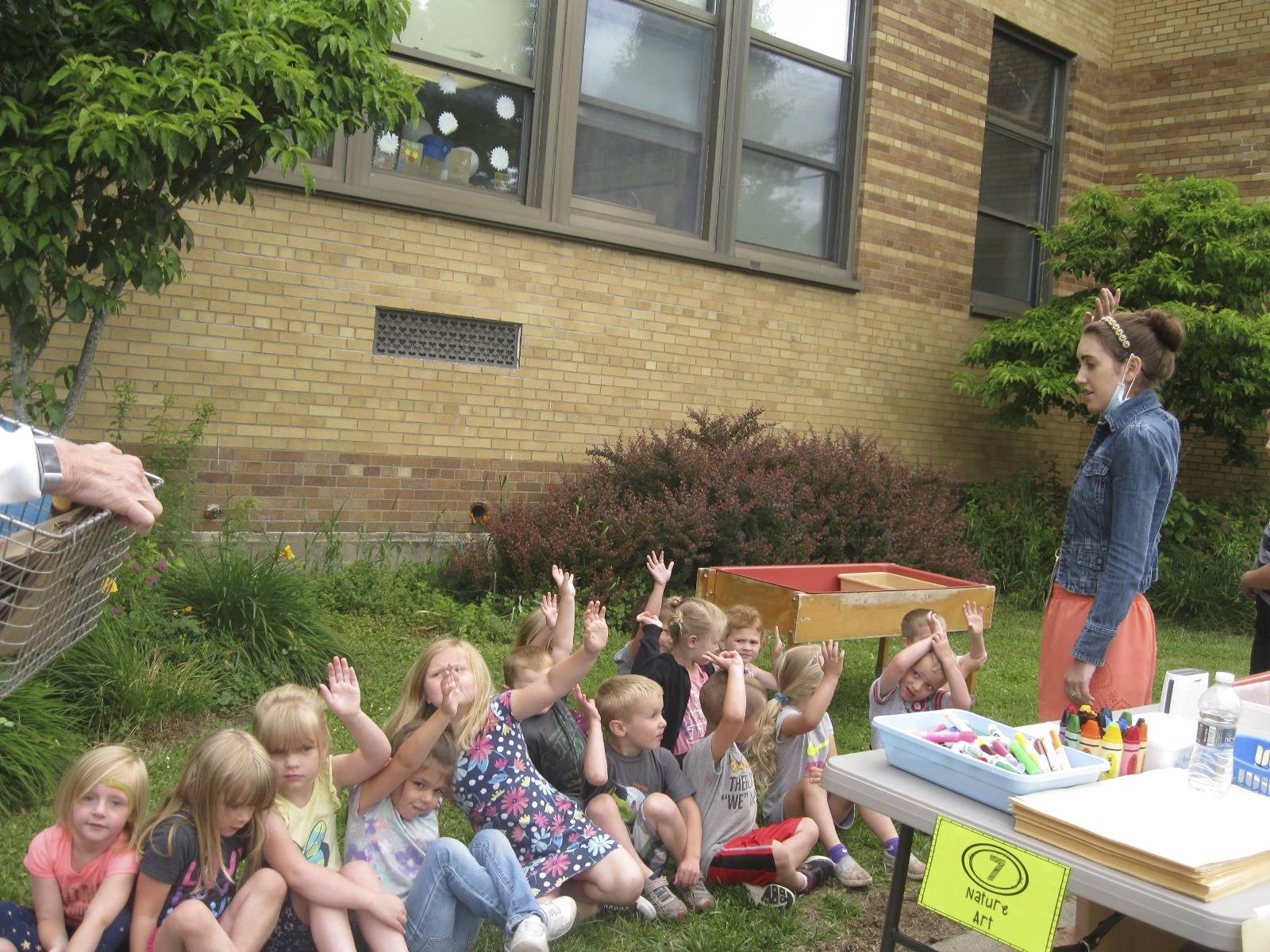 students raise their hands at  nature painting.