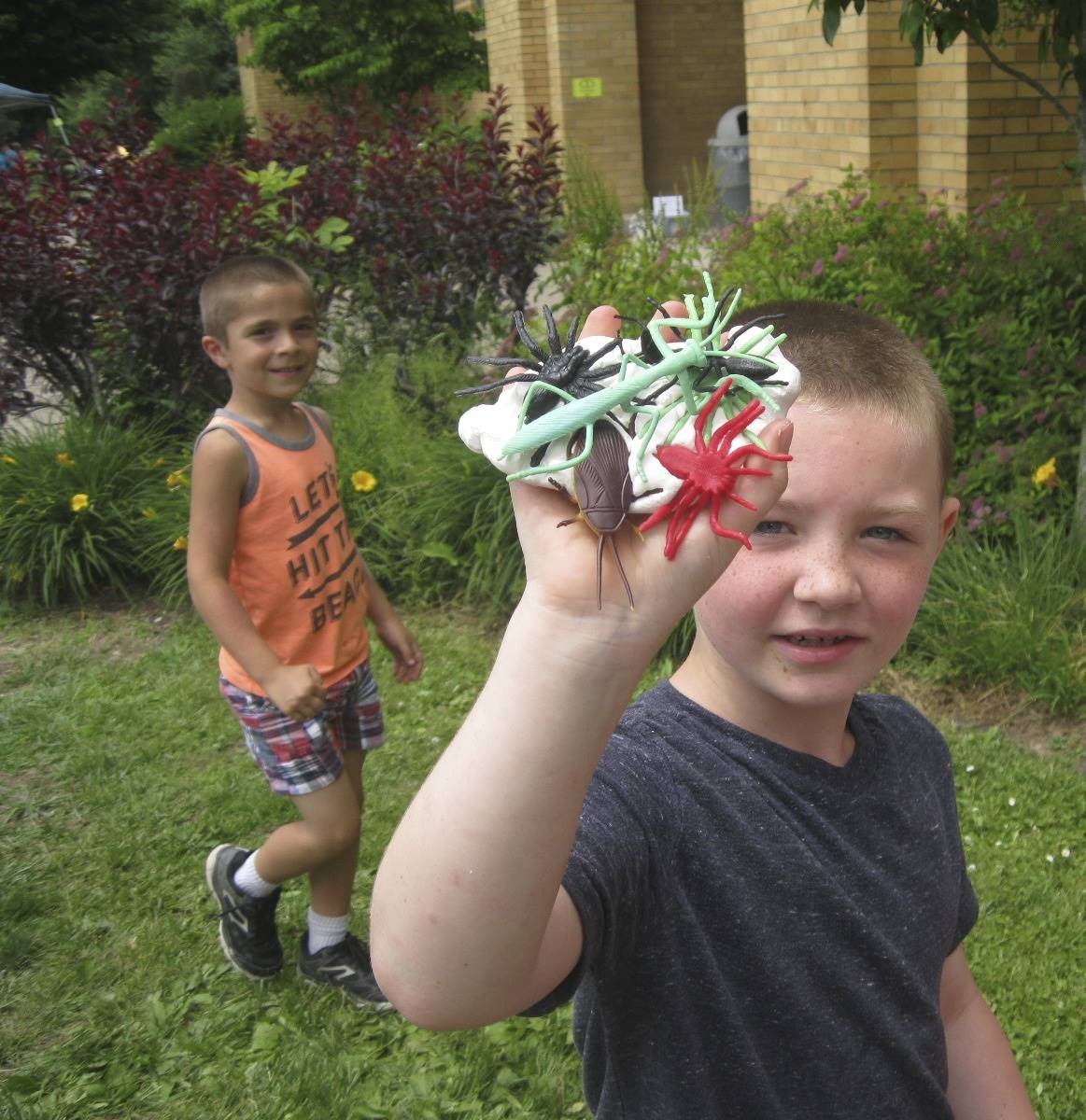 a studen holds up bug creatures.