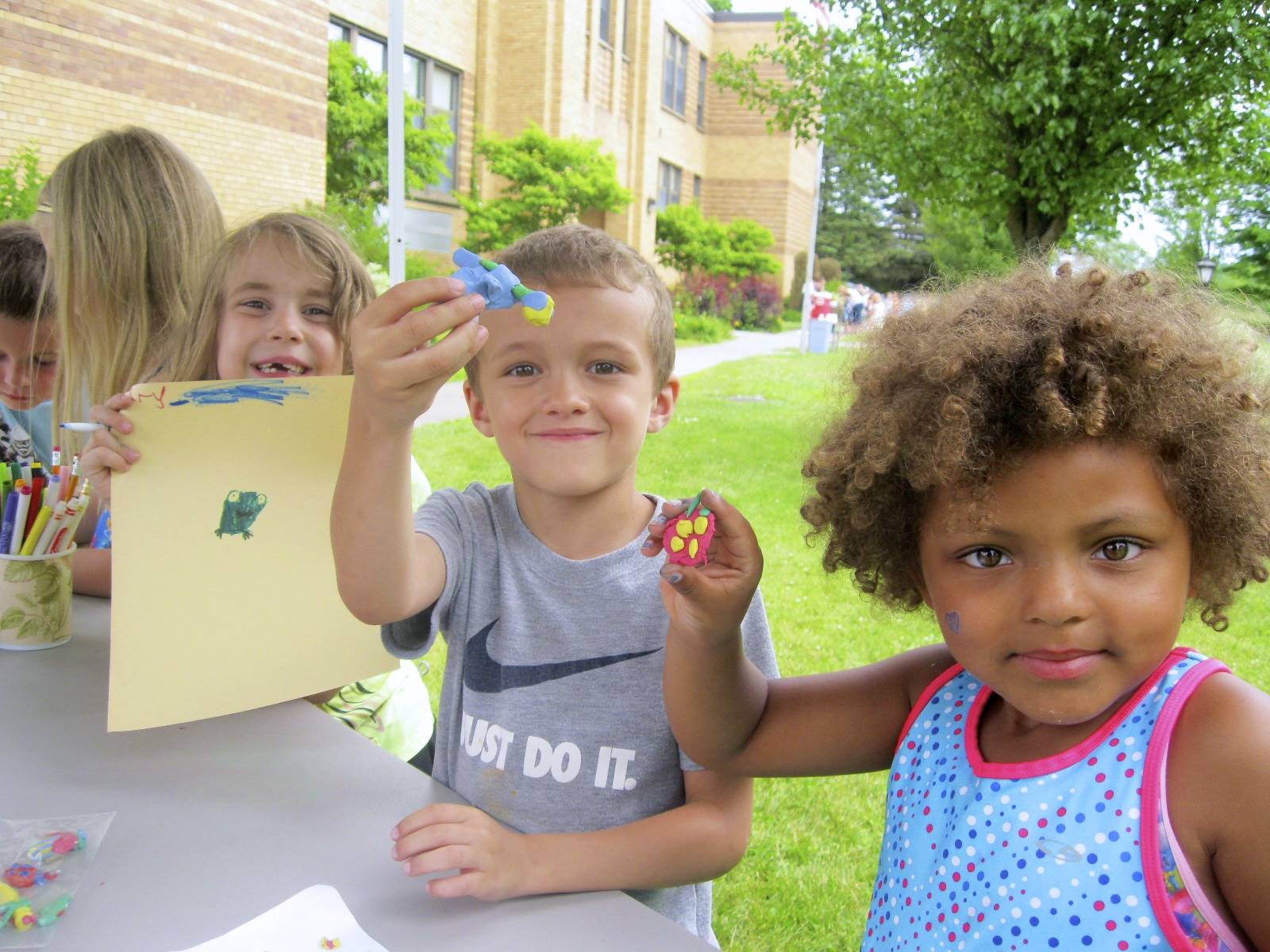 students show off the clay bugs they created.