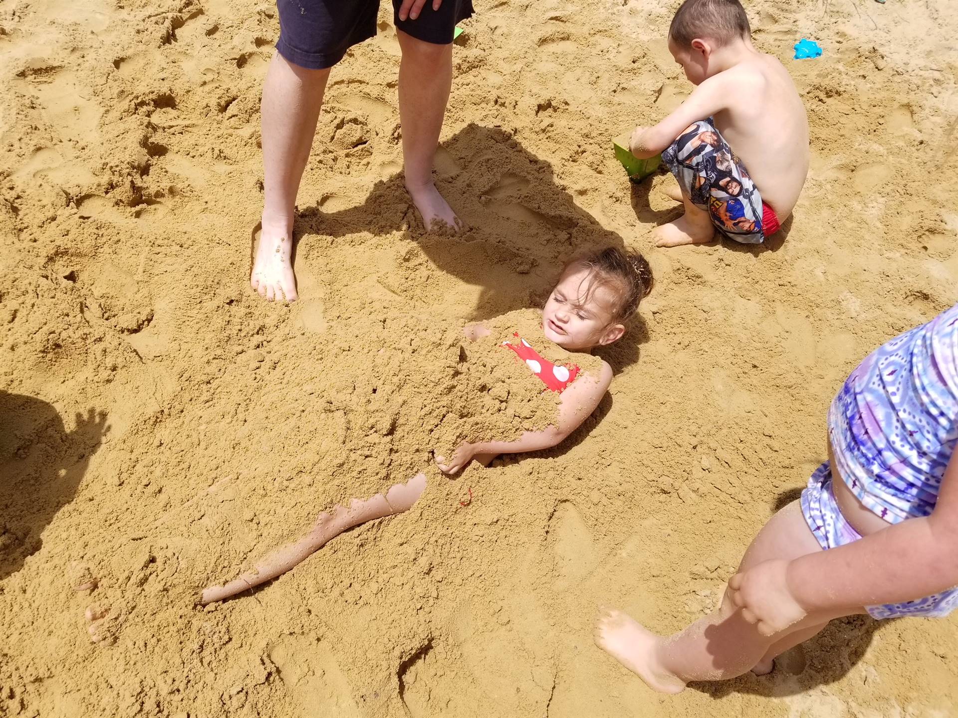 a student buried in the sand.