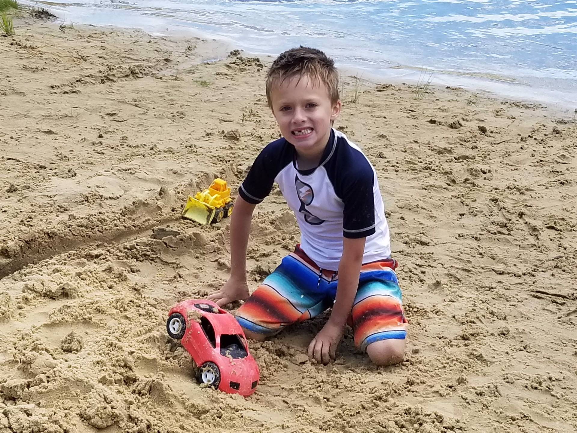 student experiments with a car in sand.