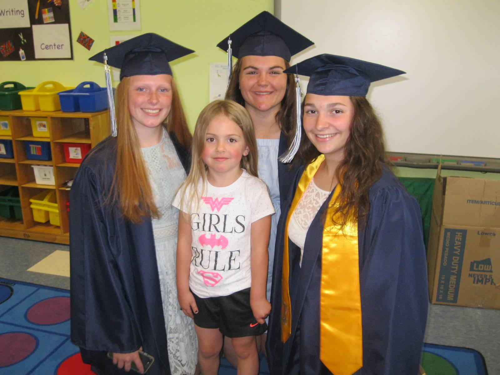 3 Seniors pose with a pre-k student