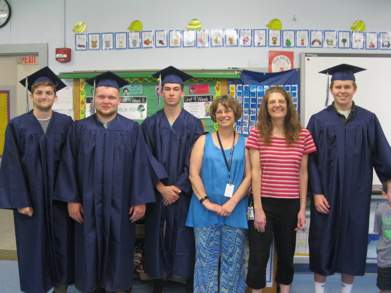 4 seniors pose with their former teacher and school counselor