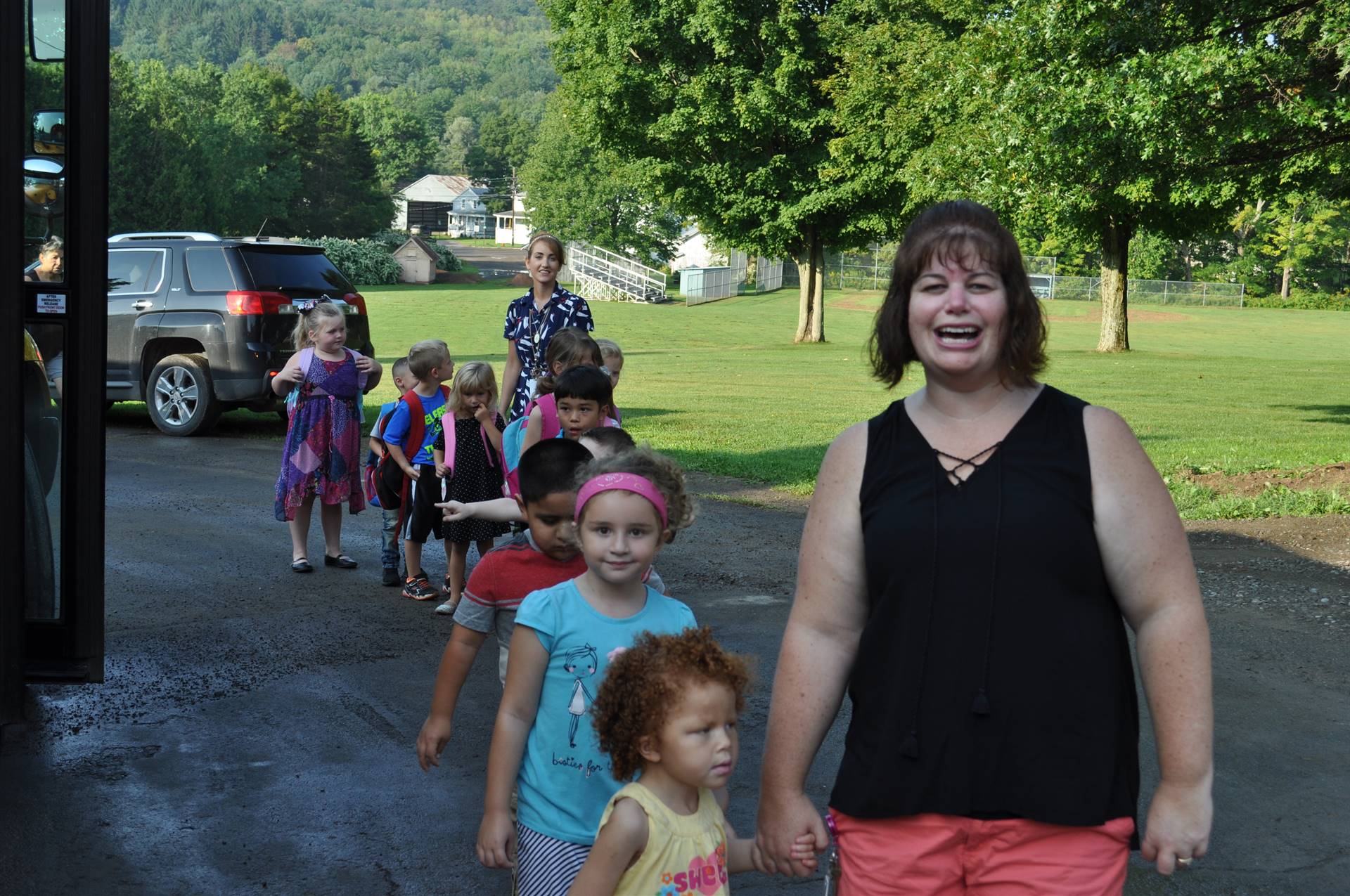 A teacher and her students enter building.