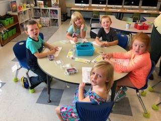 students color at a table.