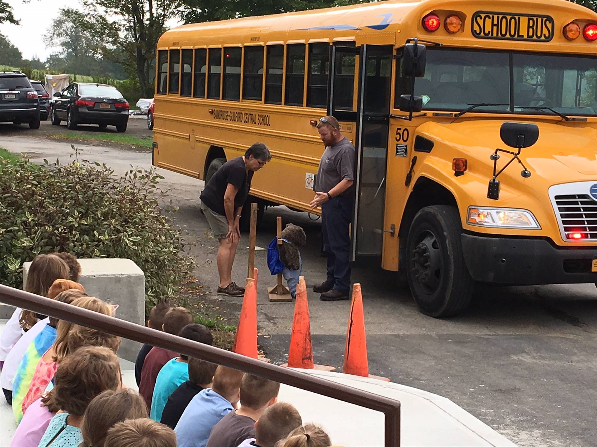 Bus driver shows student how to get on bus.
