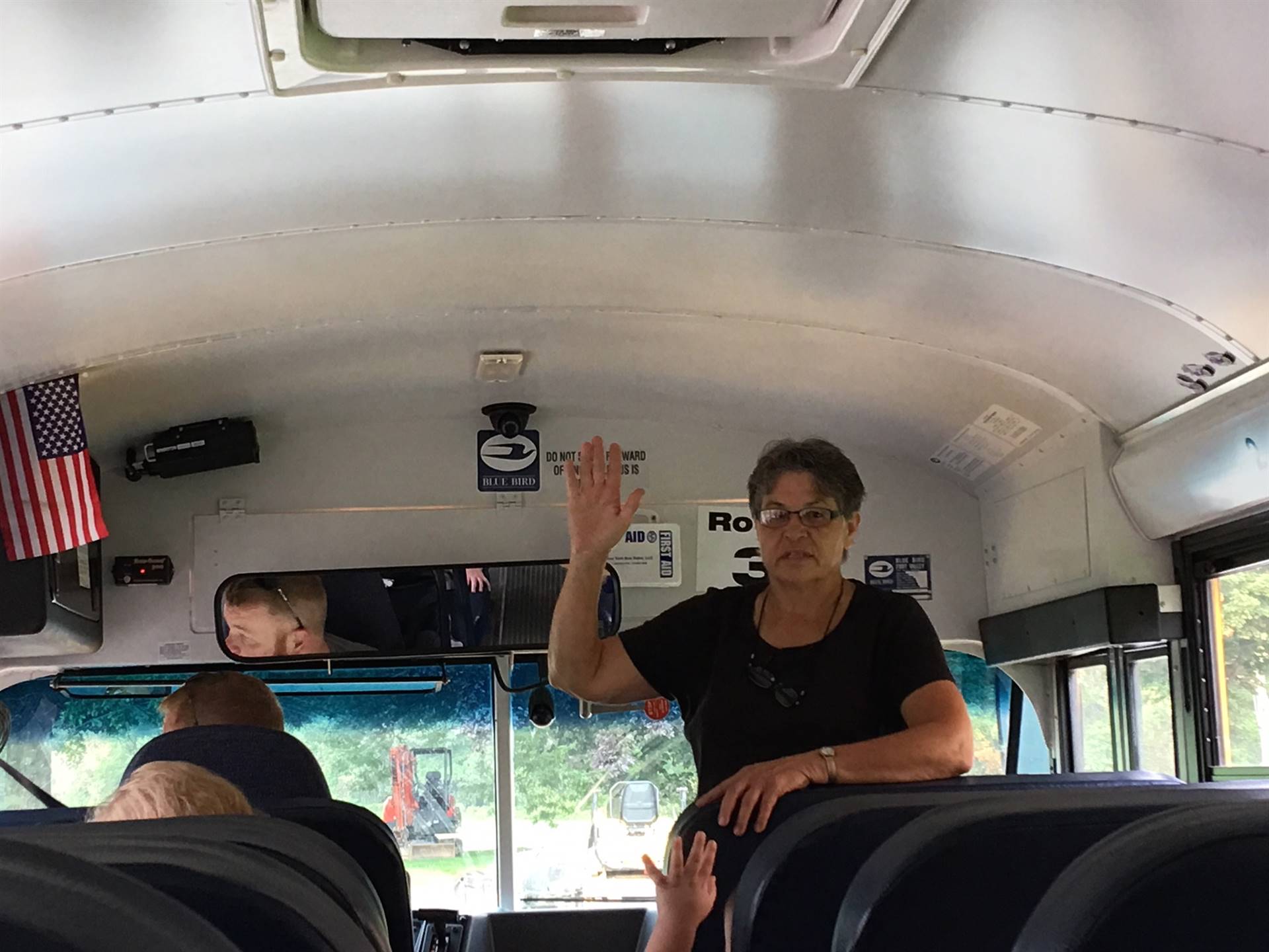 Bus driver shows how to quiet students on bus.