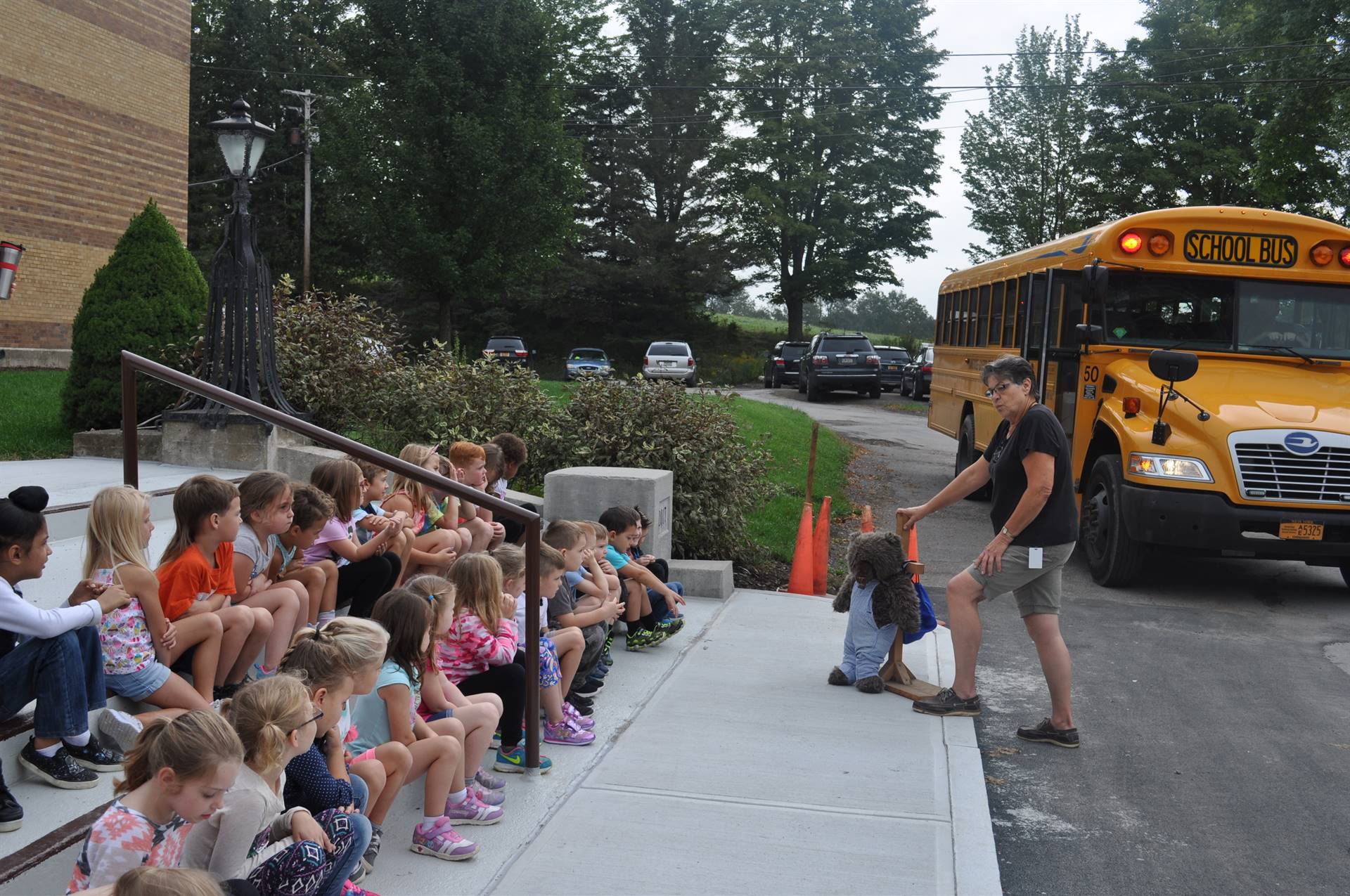 Students listen to bus driver talk about safety.