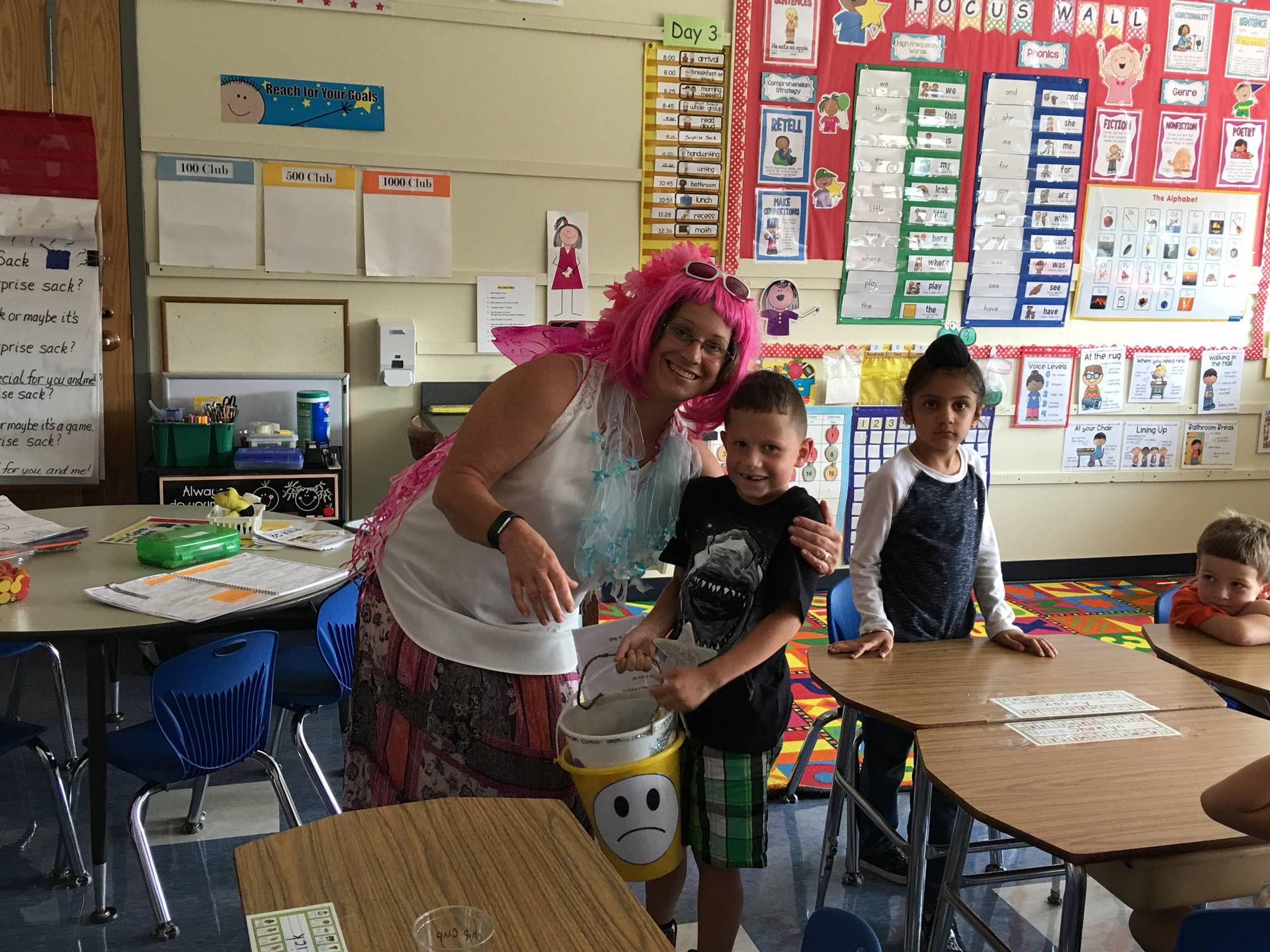 The Bucket Filling Fairy poses with 2 students.