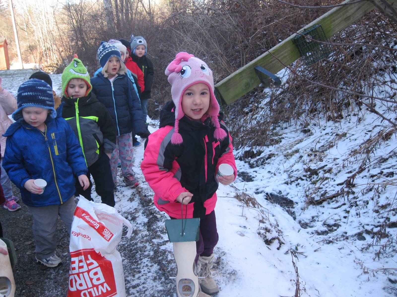 Students take turns feeding birds.