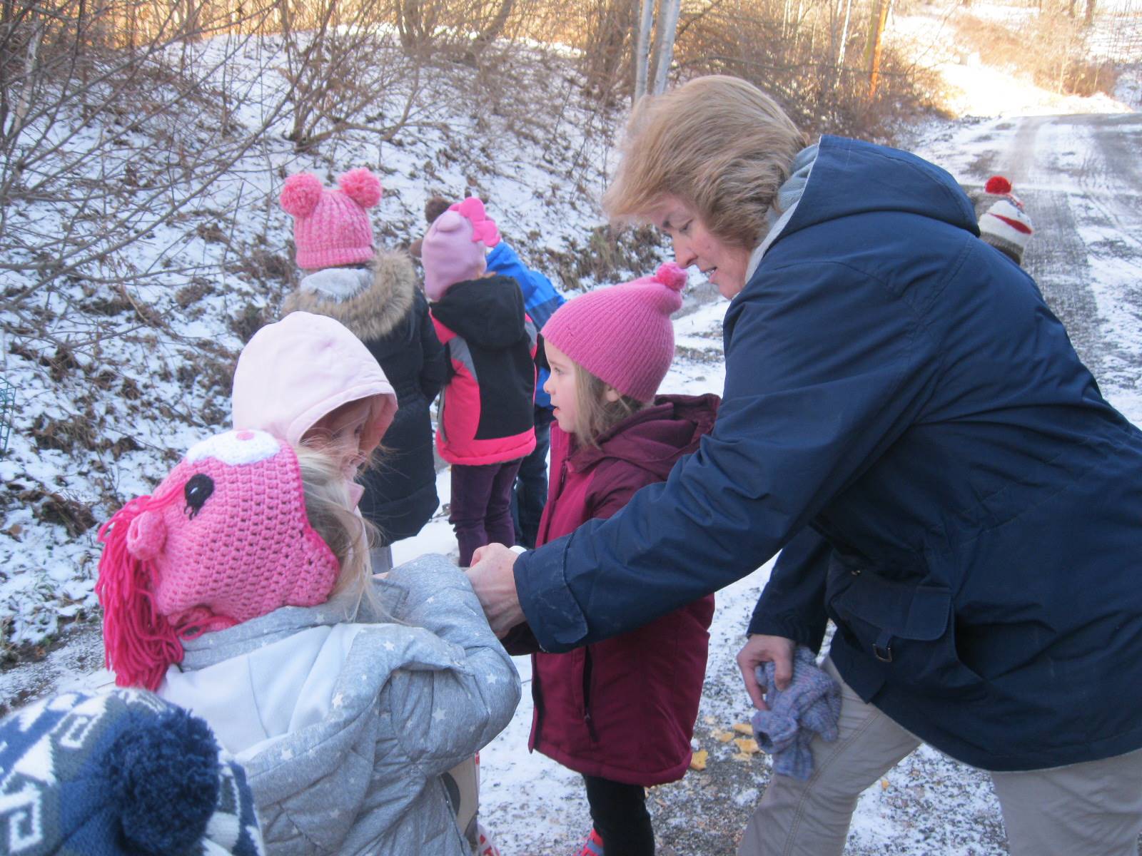 Students and a staff member help feed birds. 