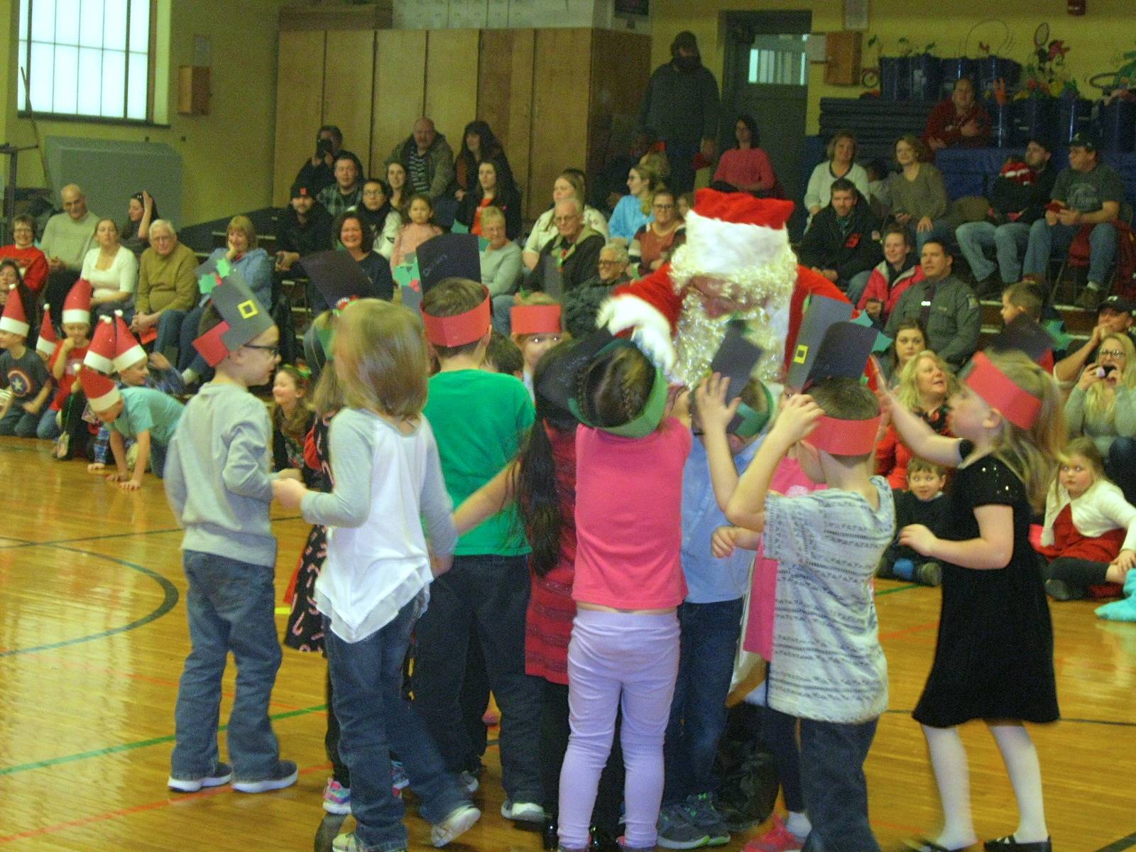 Santa gets a group hug from students.