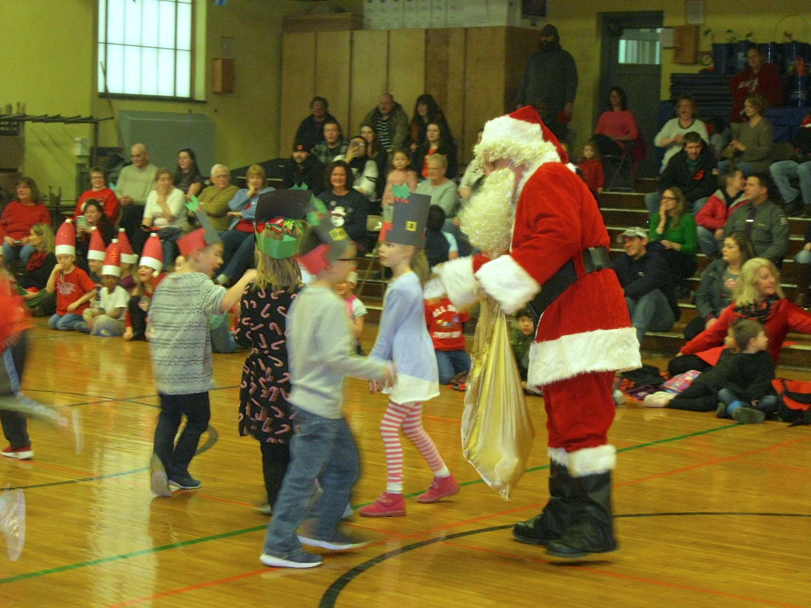 Santa reaches into his sack for presents for students.
