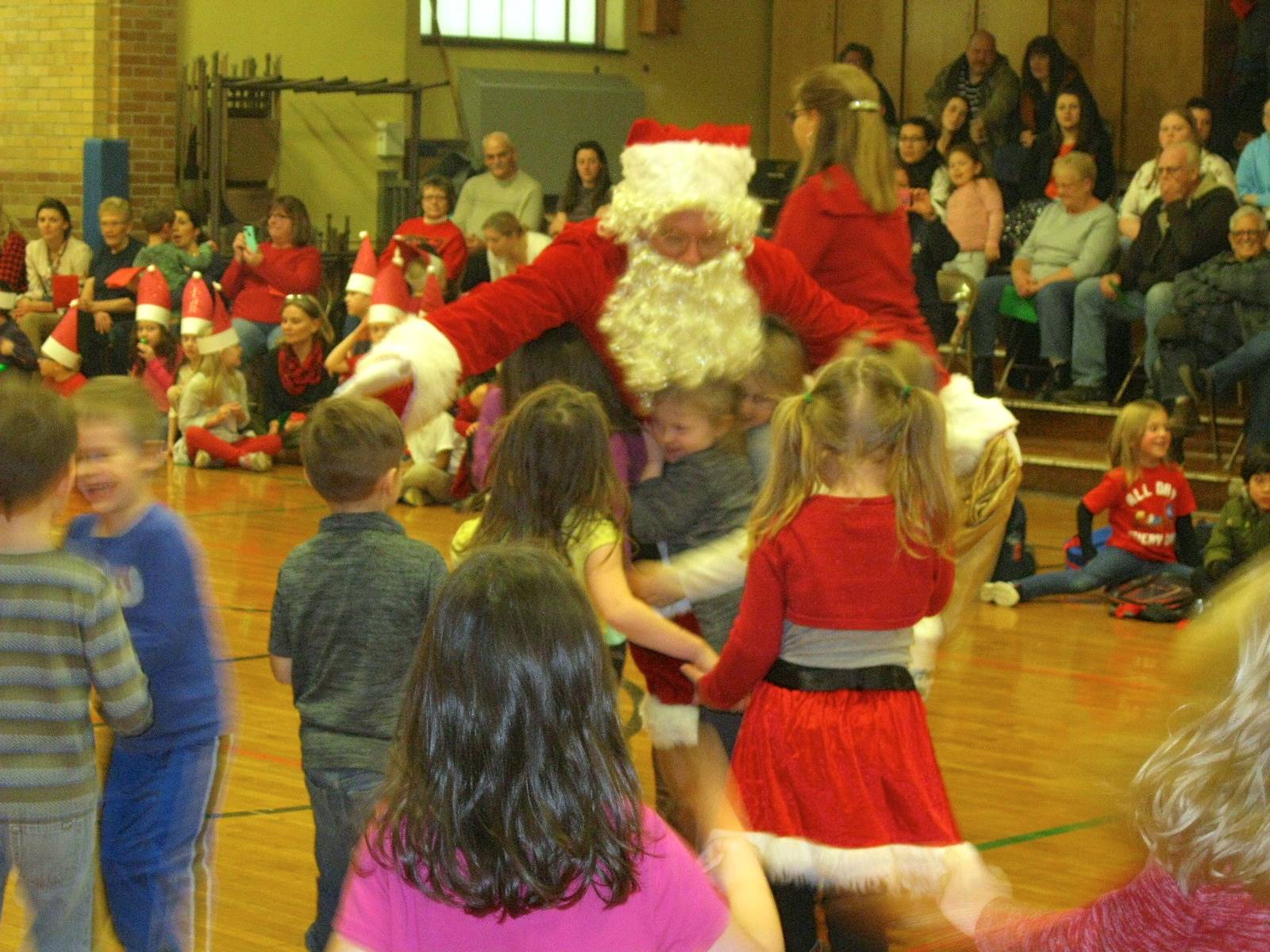 Santa and his helper talk to students.