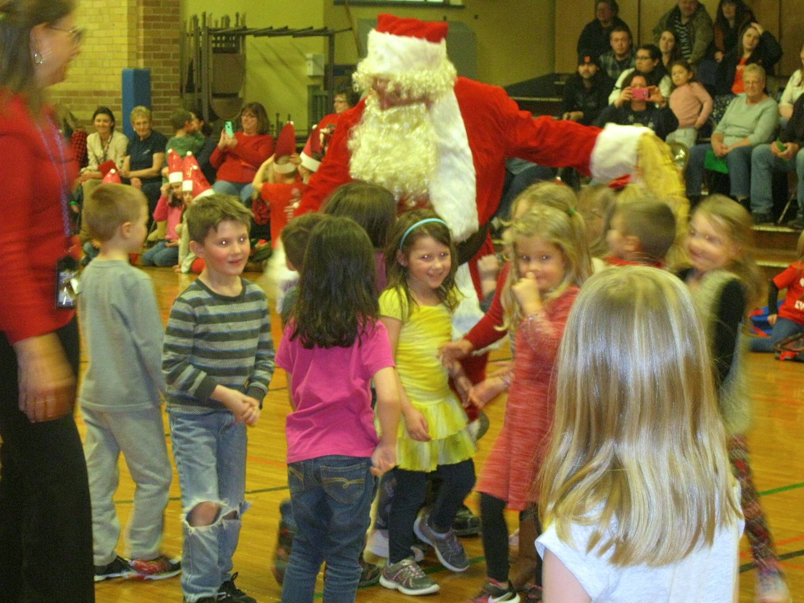 Santa and his helper talk to students.