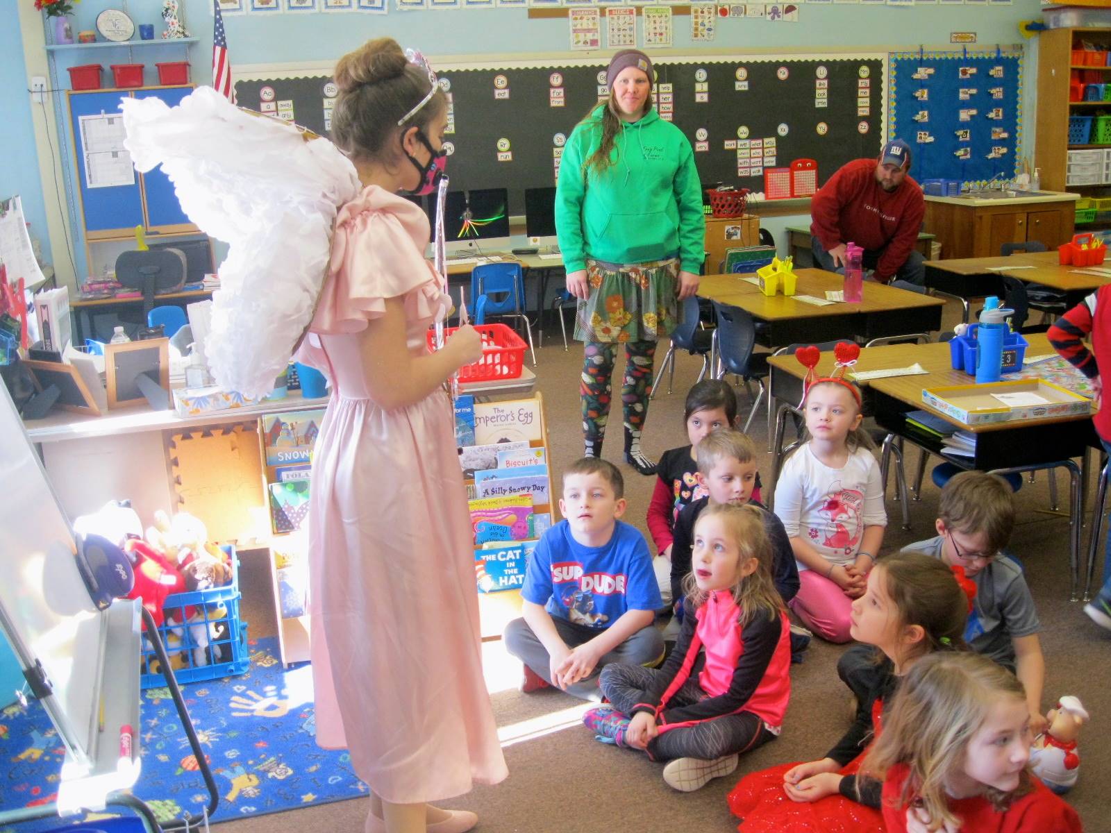 Cupid talks to a group of students about friendship.