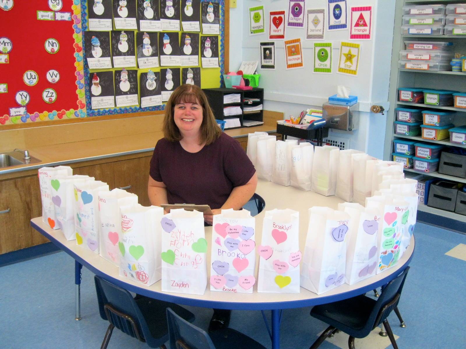 A teacher surrounded by valentine's bags of goodies!