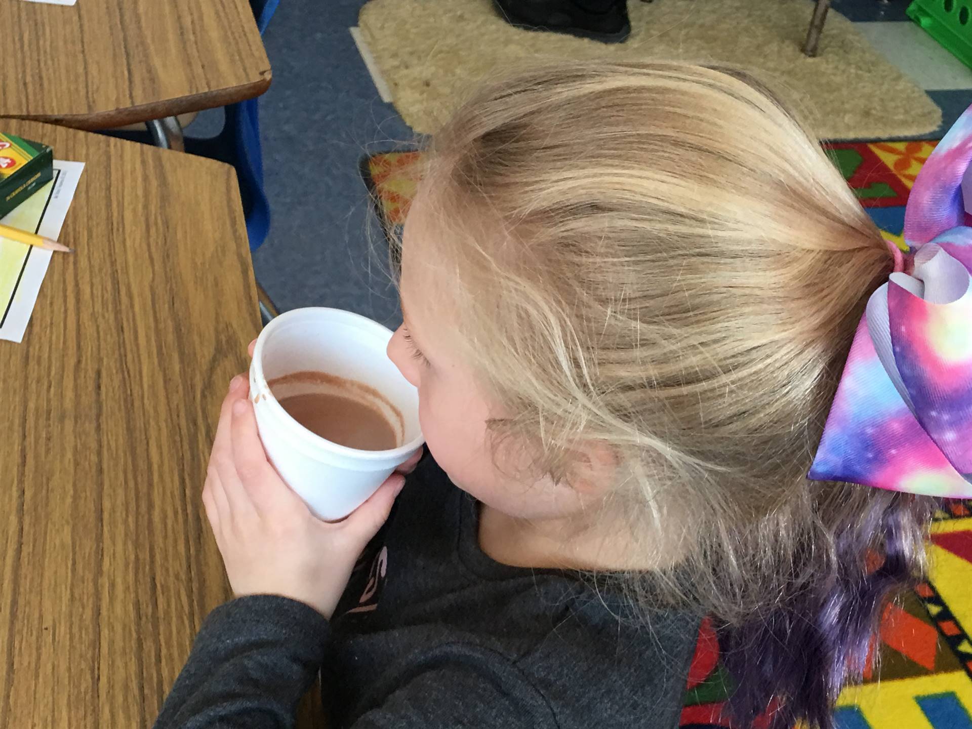 student smells hot chocolate.