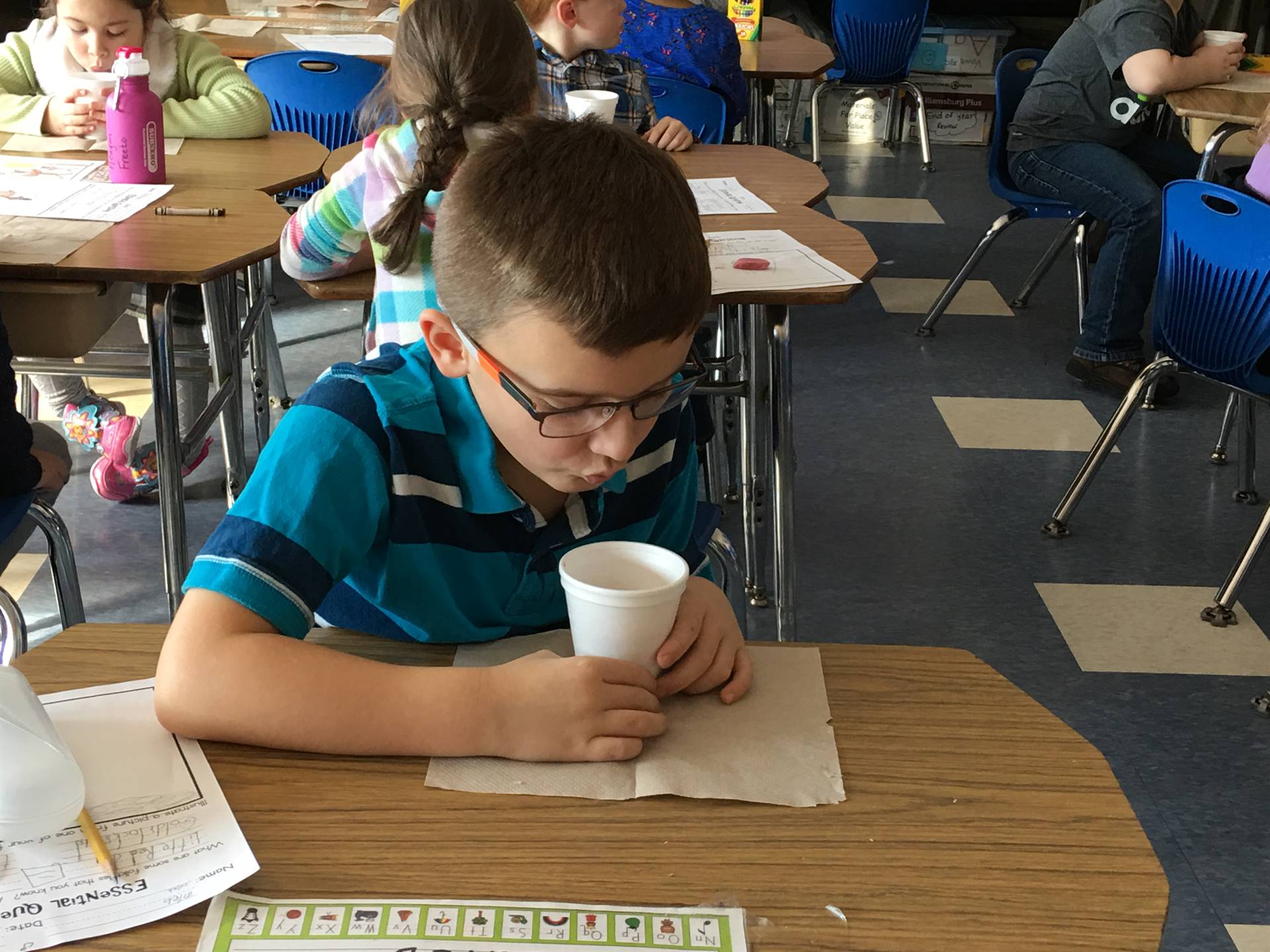 Students blows on hot chocolate.