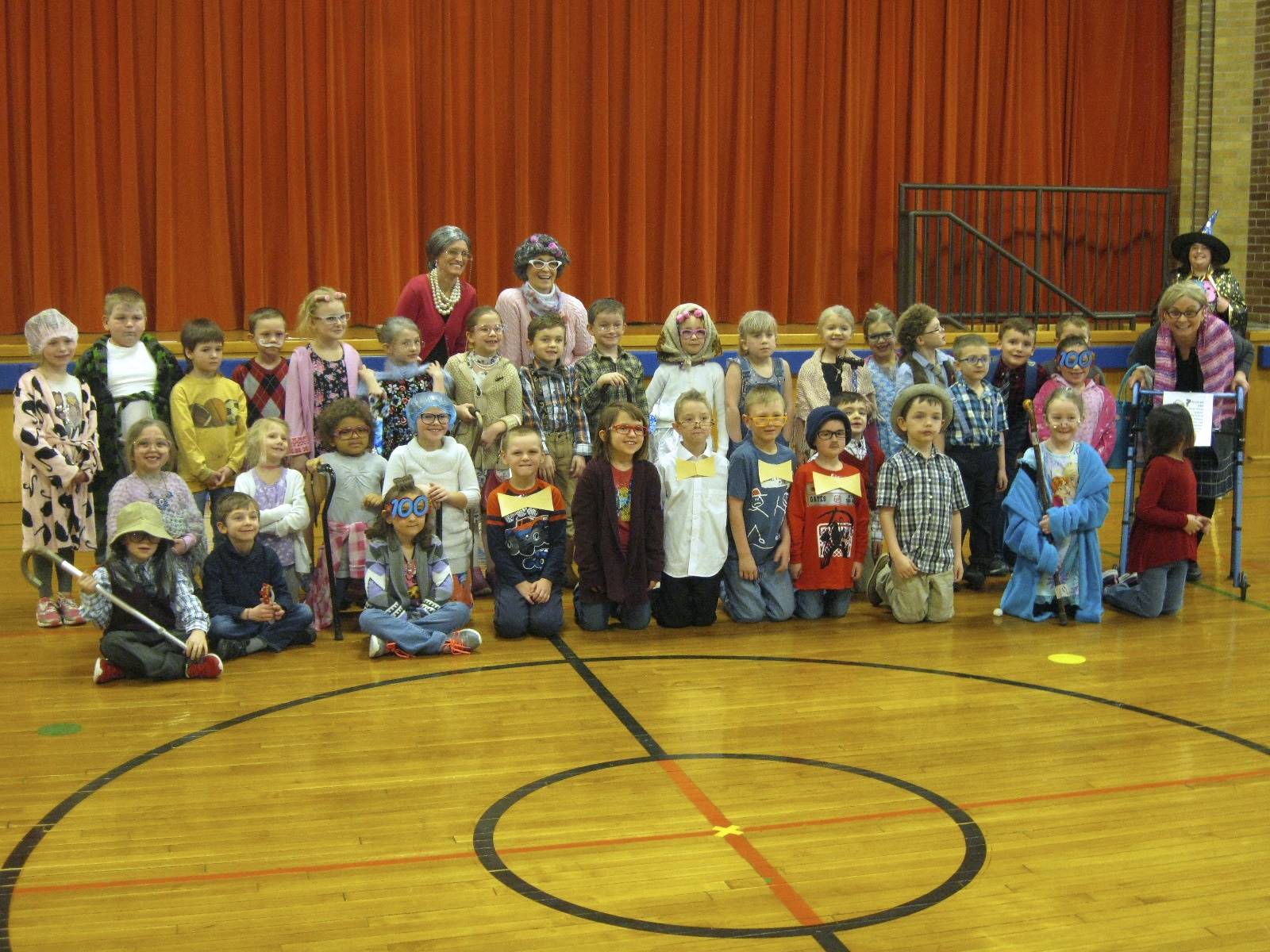 teachers and staff with students on the 100th day.