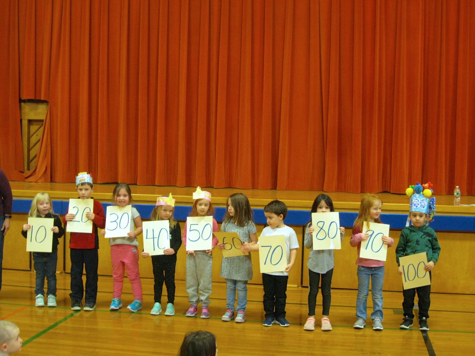 Students holding signs counting by 10 to 100.