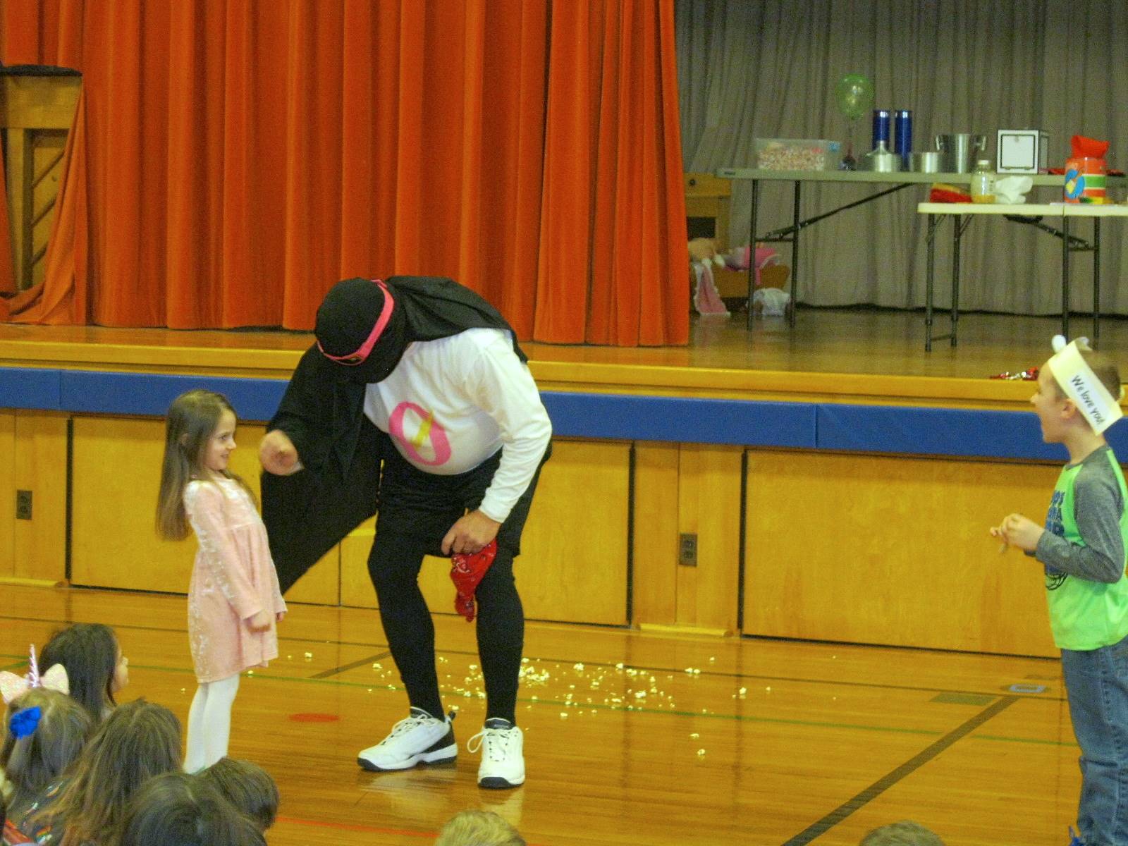 Zero the Hero and 2 students do a magic trick.