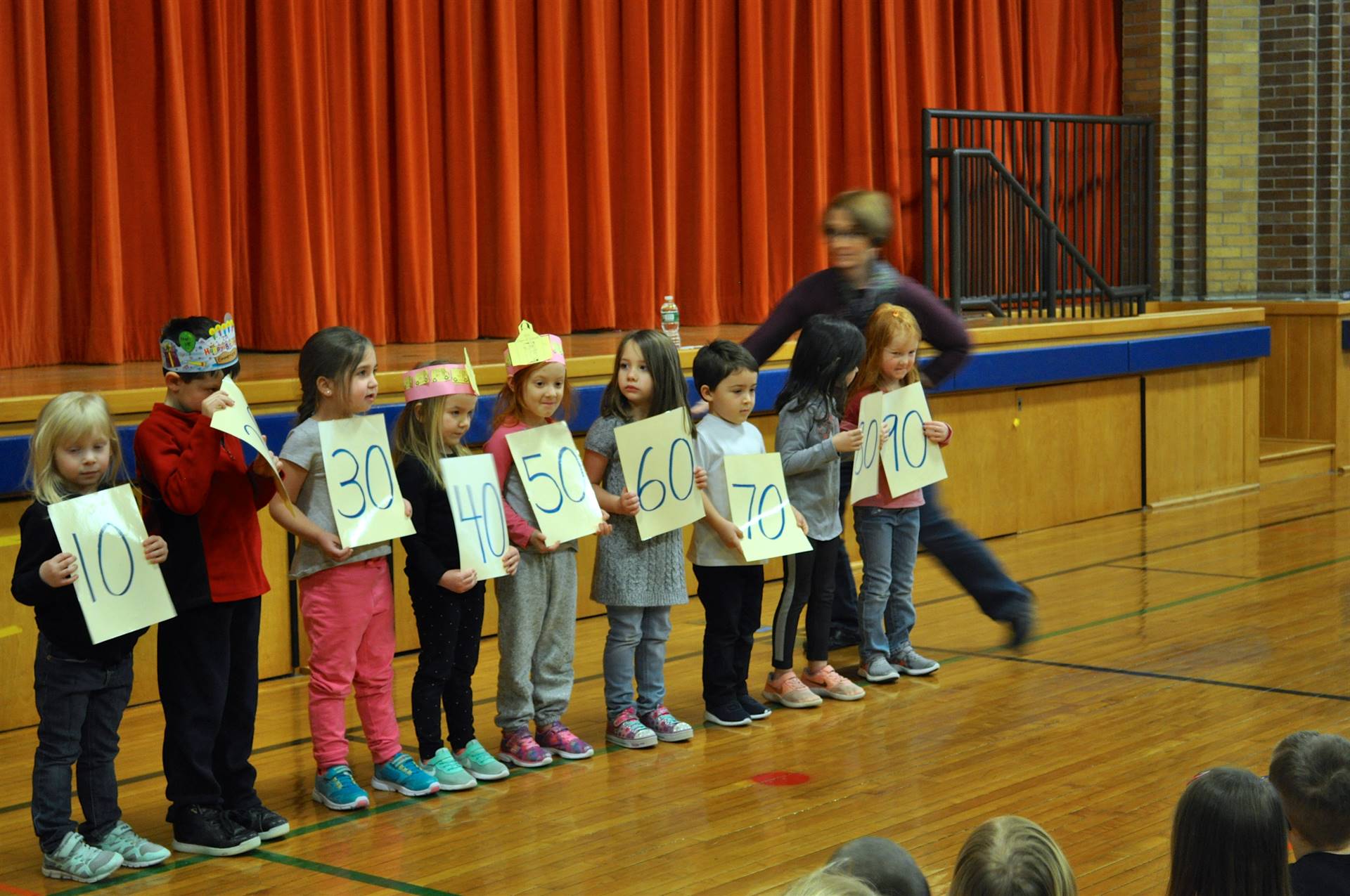 students holding signs counting to 100 by 10's.