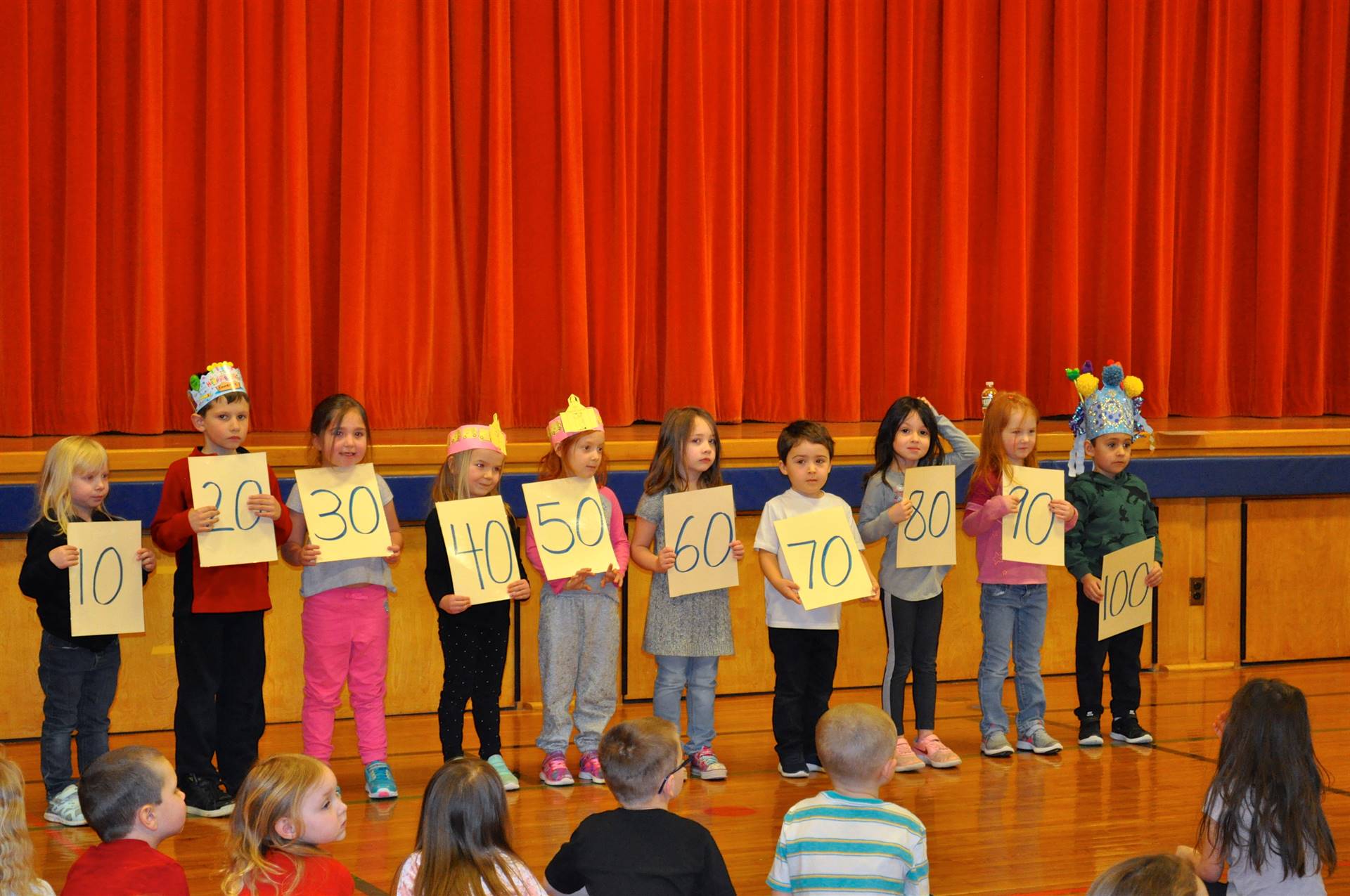 students holding signs counting to 100 by 10's.