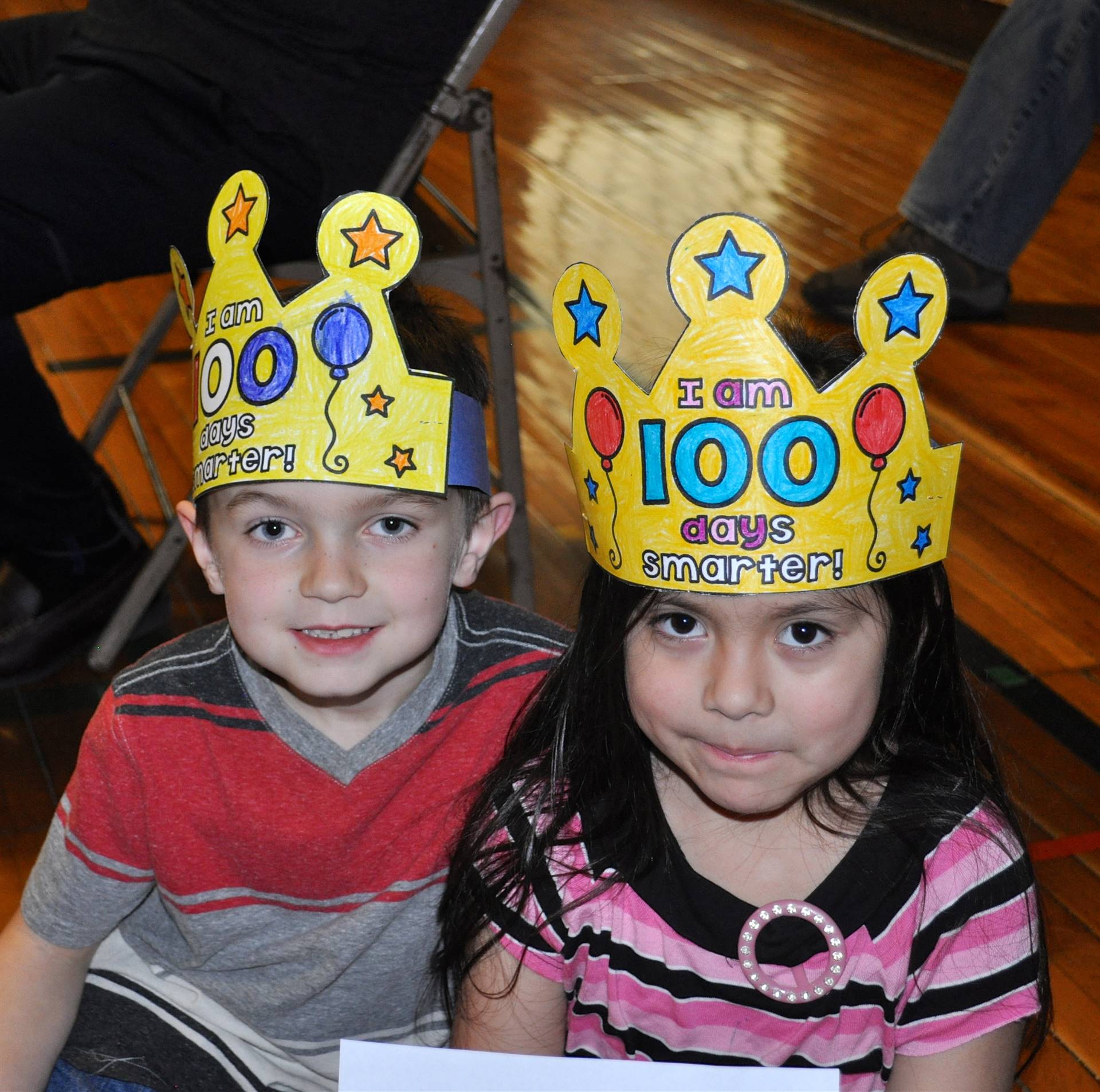 2 students wearing 100 hats.