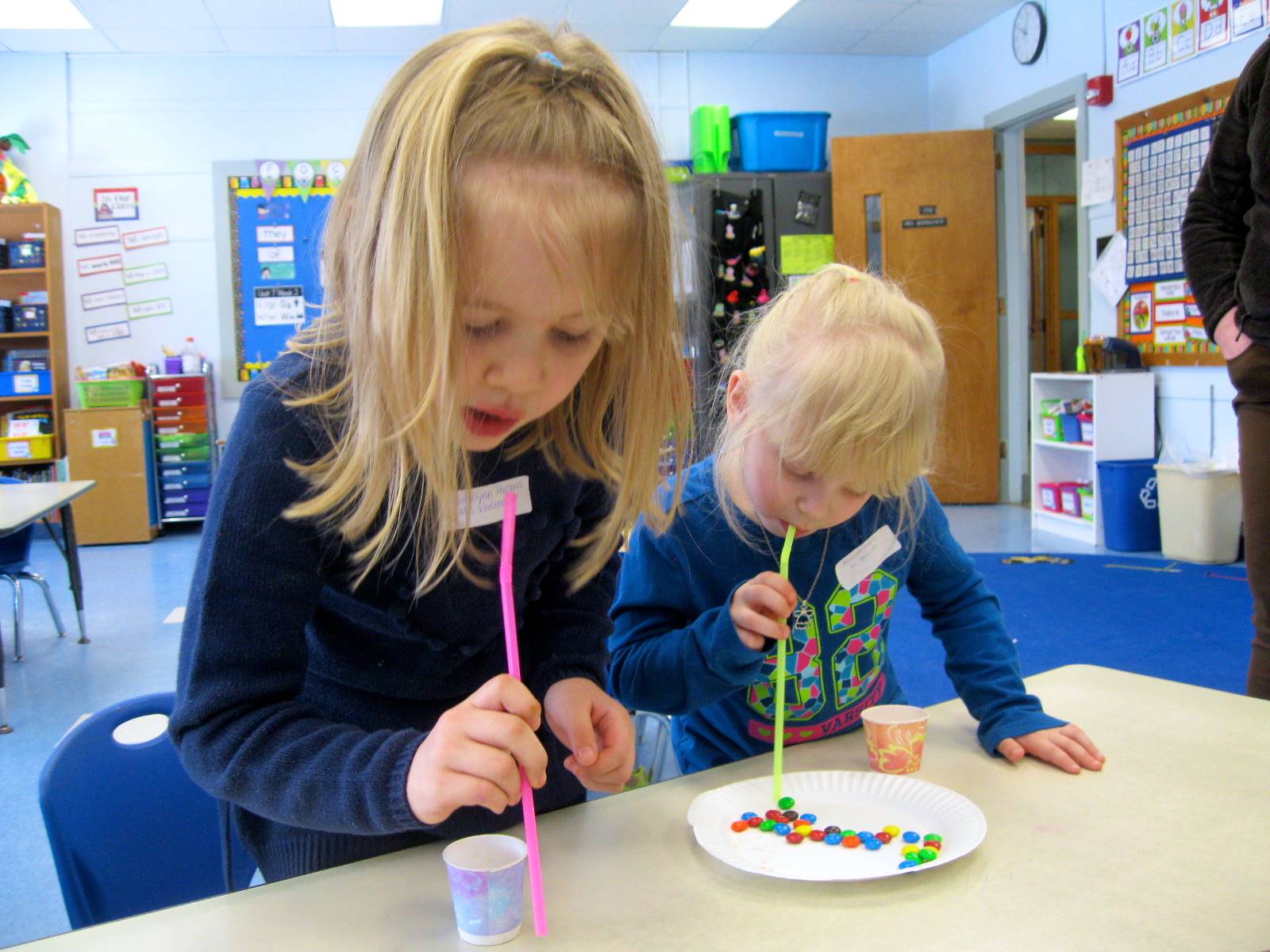 2 students using straws to move M&Ms