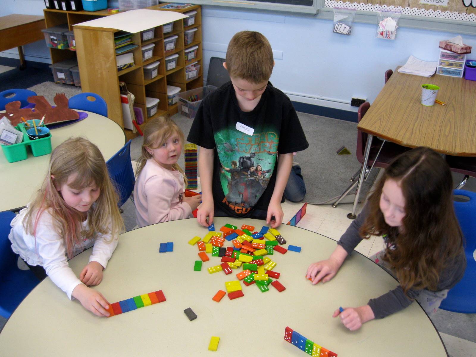 4 students build with colored blocks.