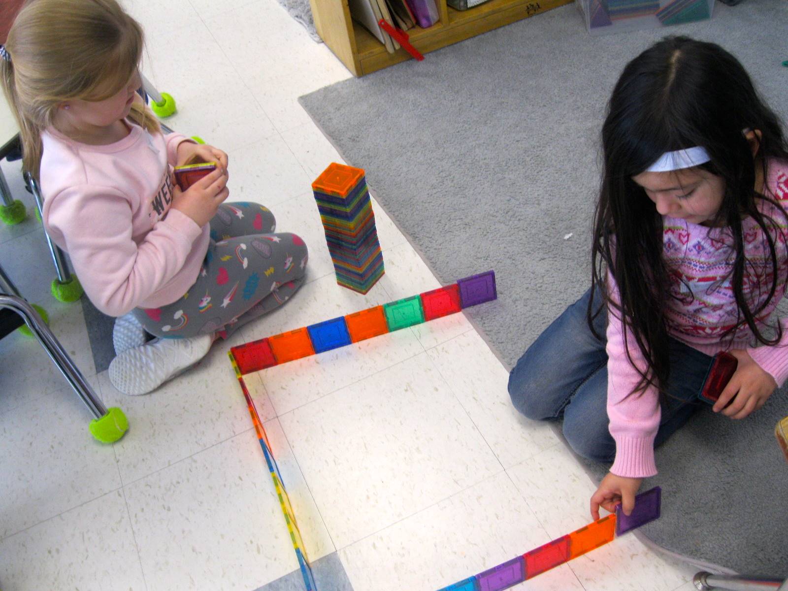 2 students build with colored blocks.