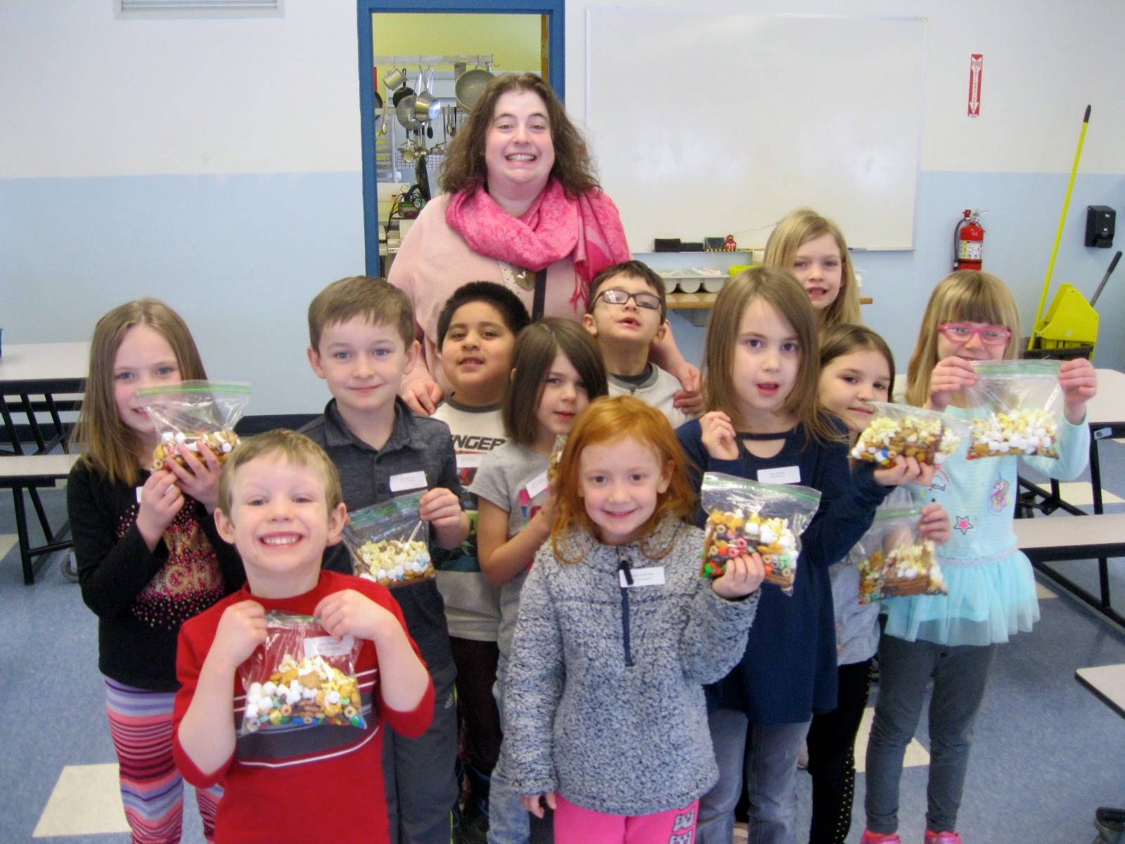 A teacher and a group of students with their 100 day snacks.