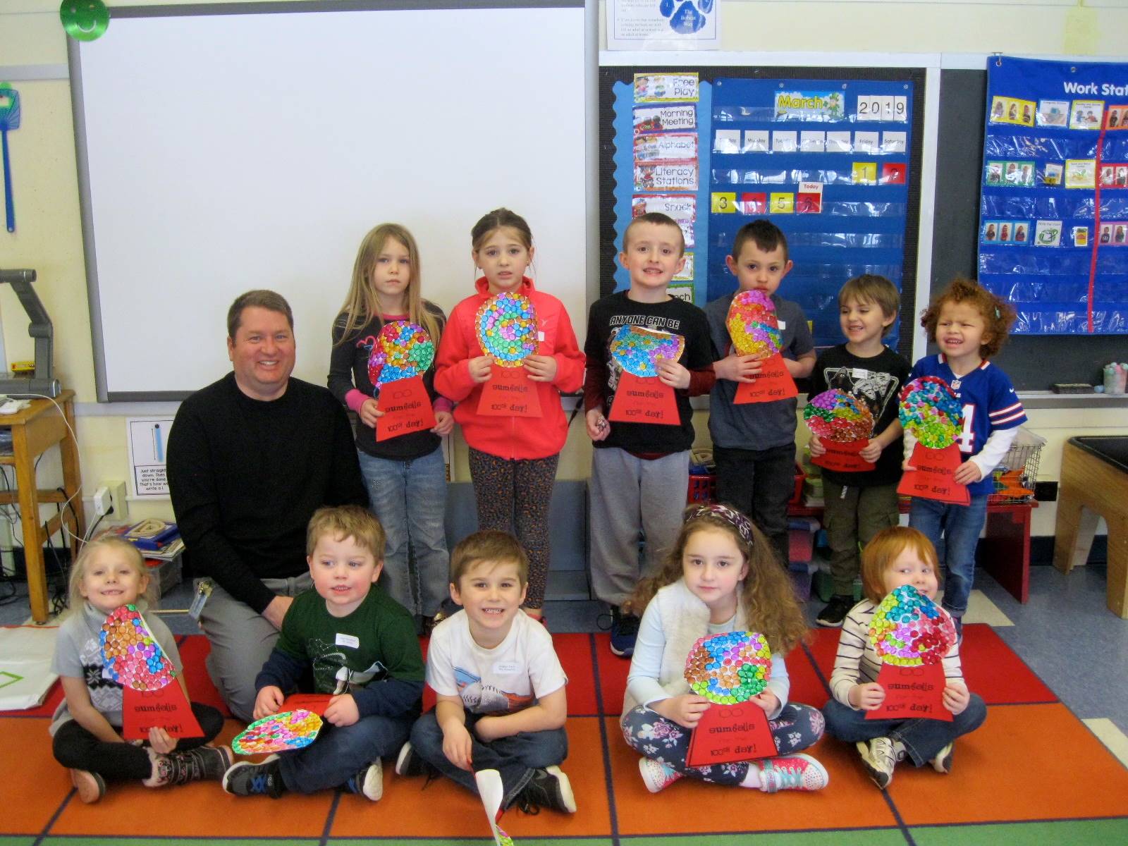 A group of students with 100 gum ball project.