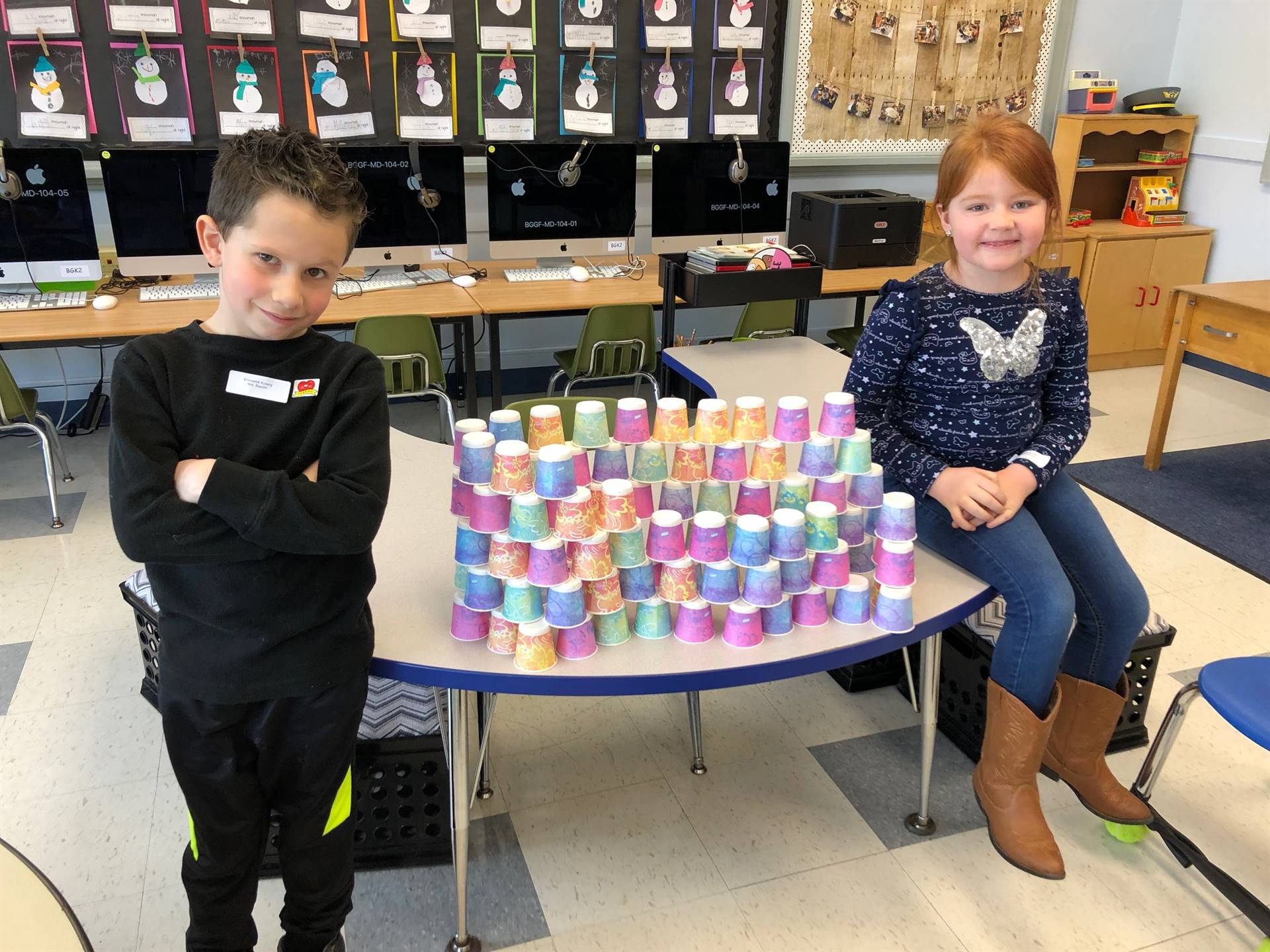 2 students with 100 dixie cup pyramid.