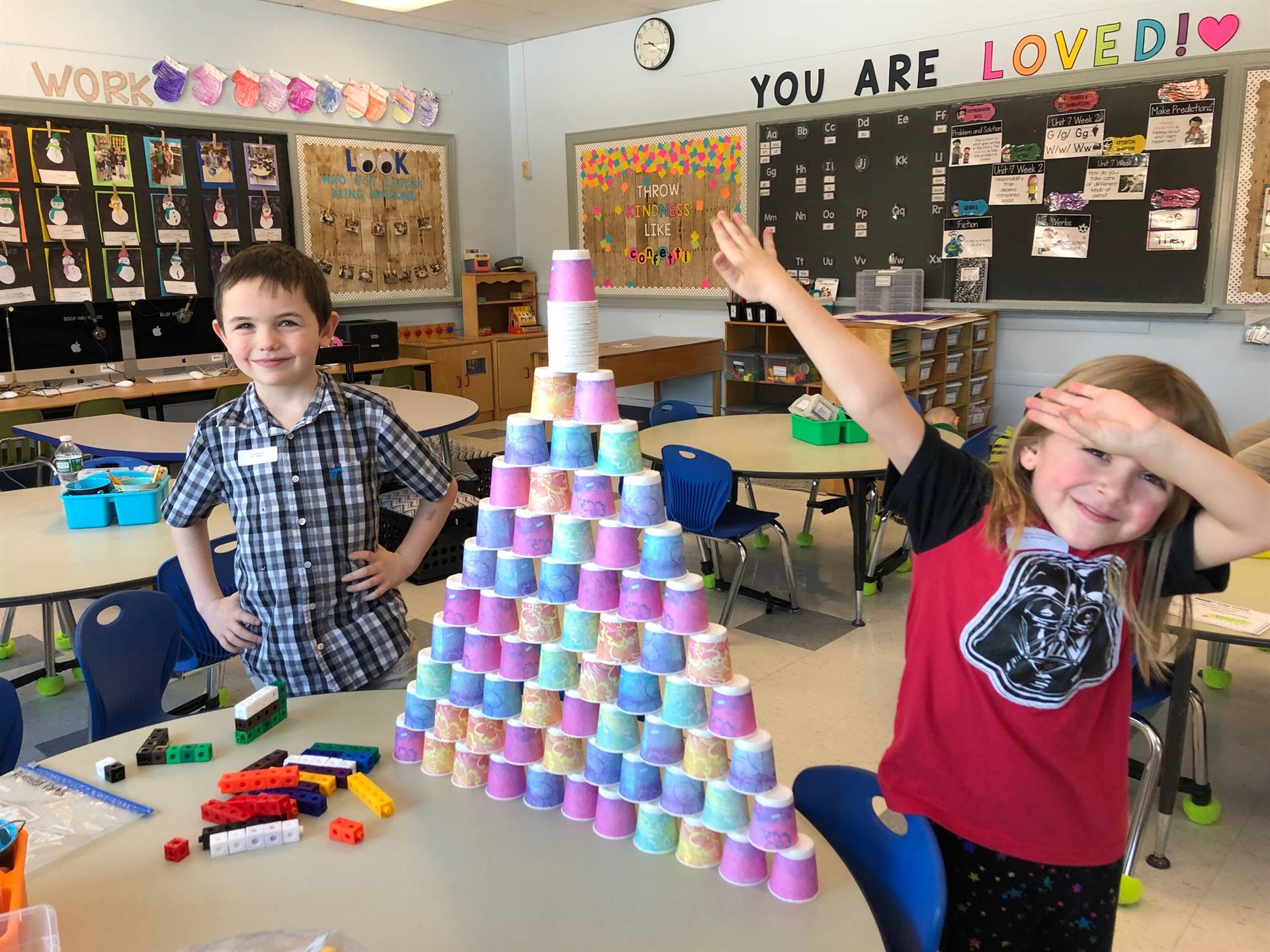 2 students with 100 dixie cup pyramid.