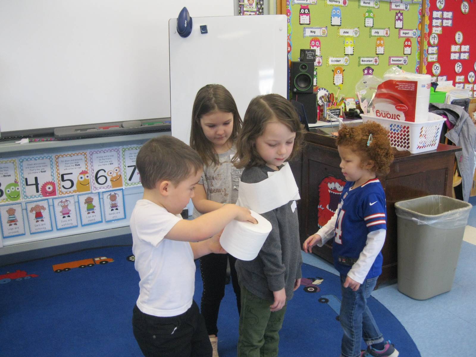 4 students playing a game with toilet paper