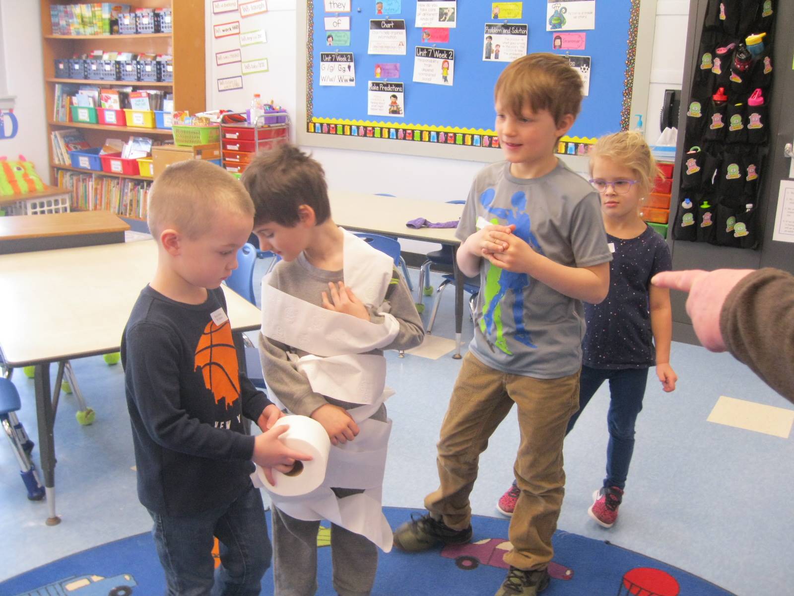4 students playing a game with toilet paper