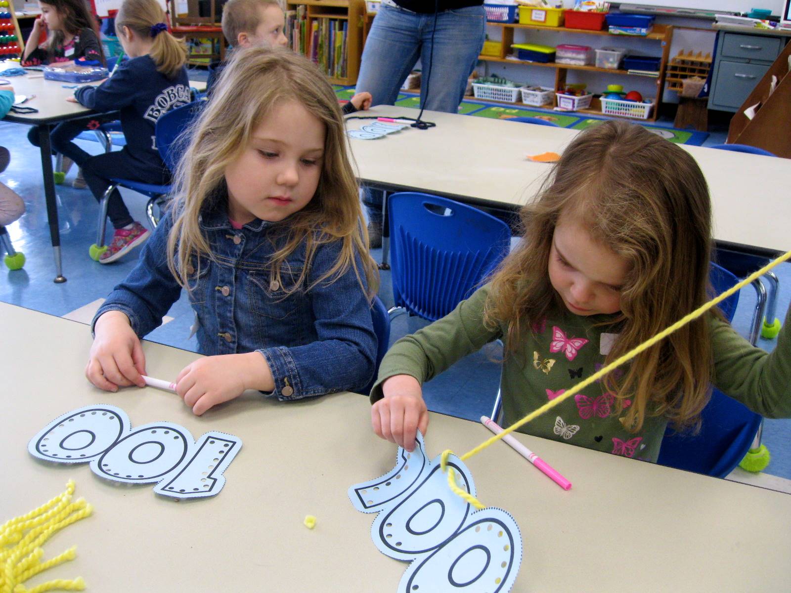 2 students sew a 100 necklace