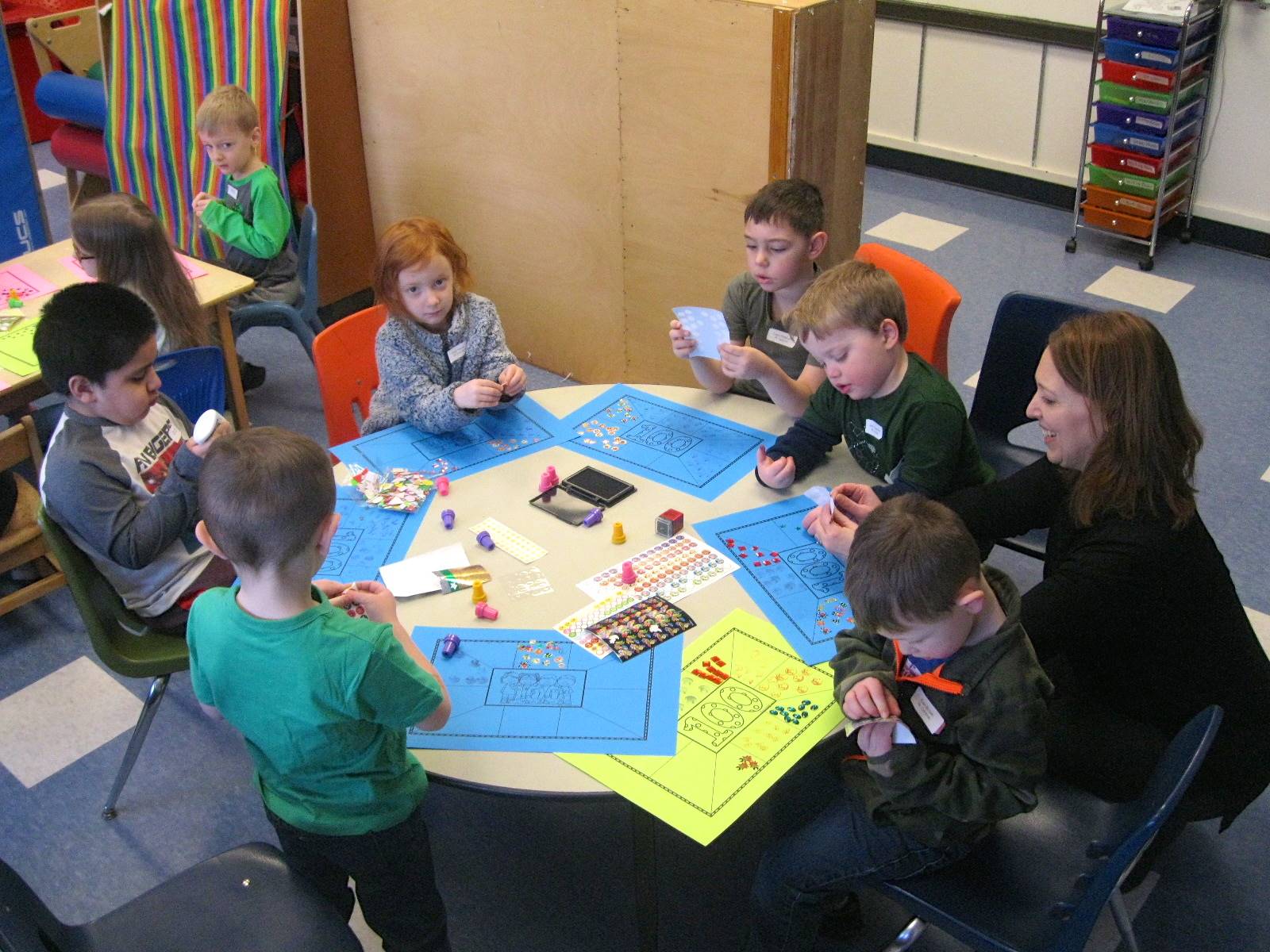 A group of students applying 100 stickers to a mat.