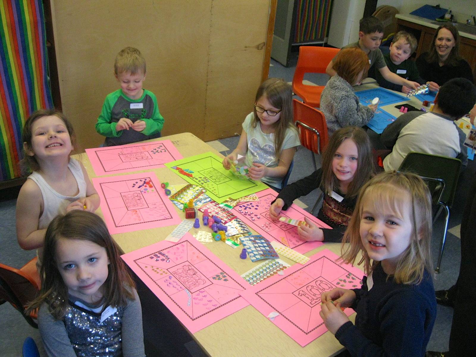 A group of students applying 100 stickers to a mat.